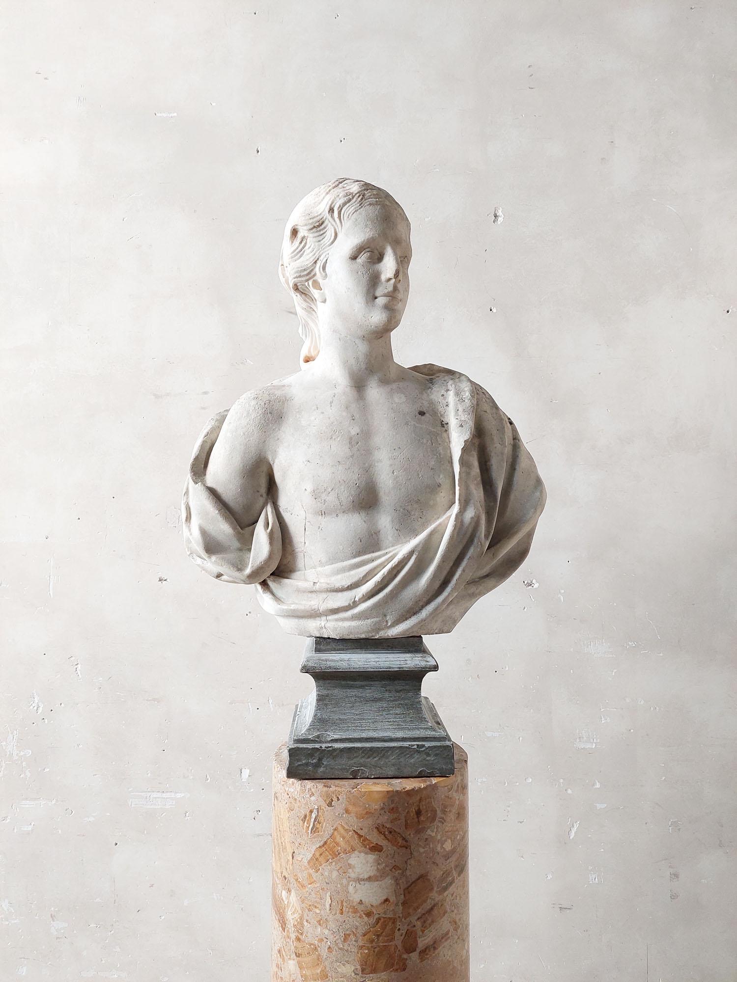Antique, 17th century hand-carved Carrara marble bust on a square bleu turquin marble base. The back has a nice rough finish, so the handcarved marks are still visible. A restoration has been done at the bottom right of the rear.

Attention: This