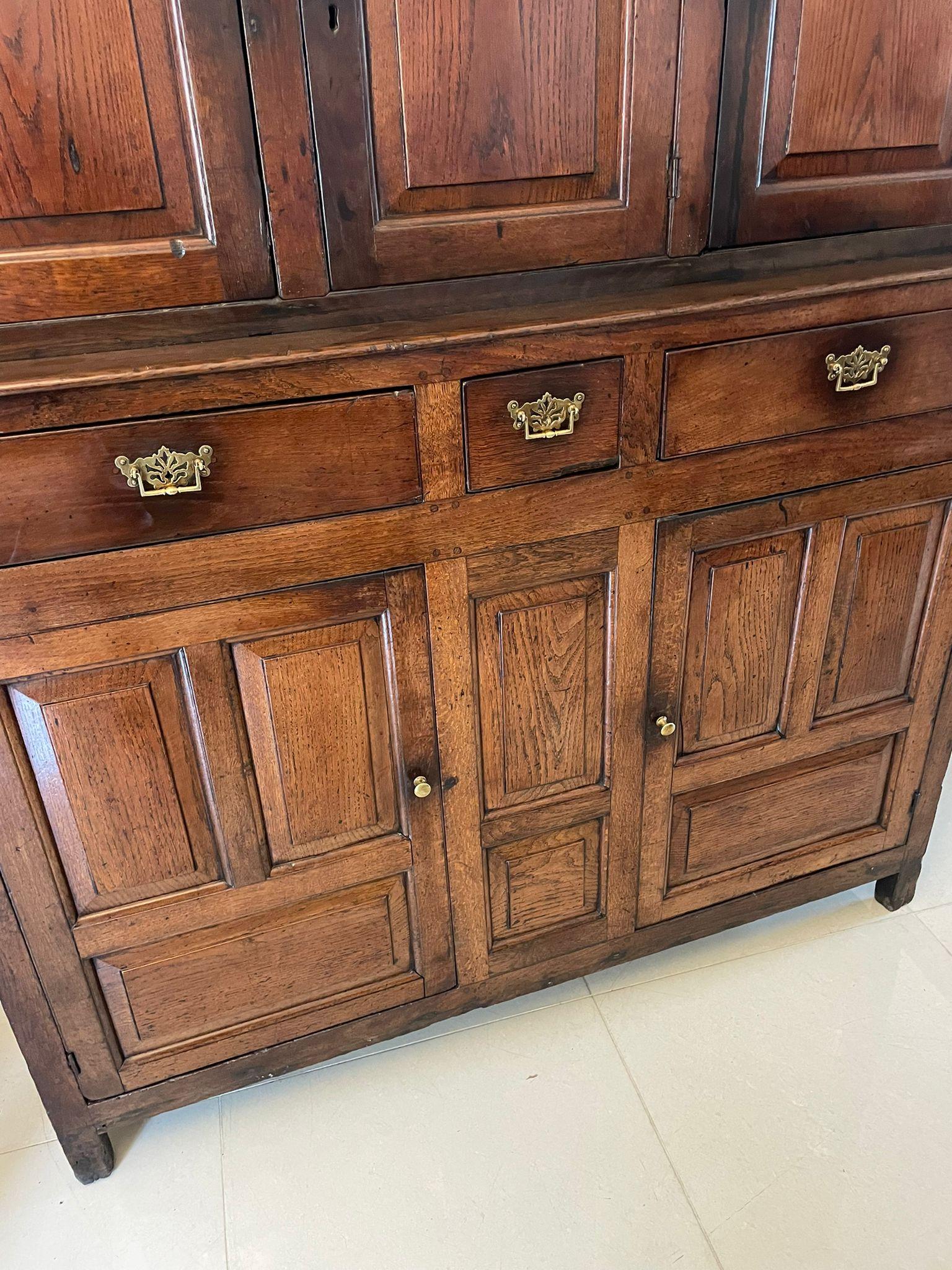 Large antique 17th century Welsh quality oak Deuddarn cupboard having a moulded cornice with turned finials, three shaped moulded edge panel doors opening to reveal a storage compartment and fitted drawers. The interior base having three drawers