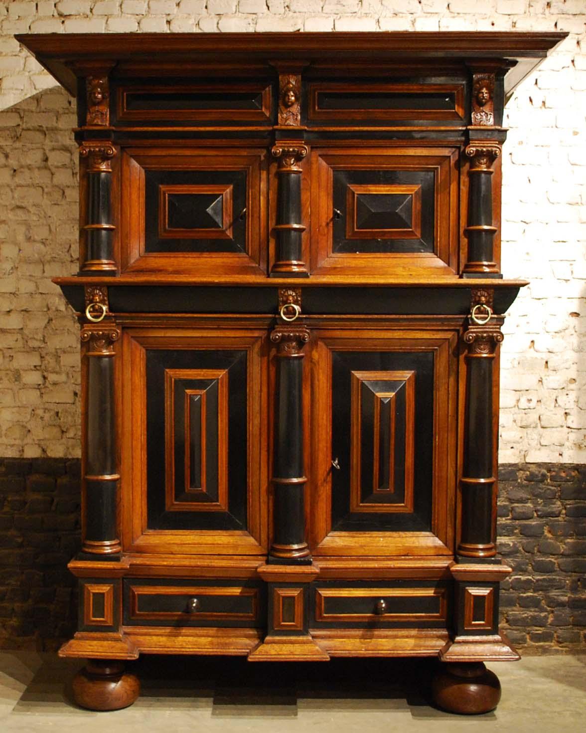 An exquisite Dutch cushion cabinet with four rectangular doors and three drawers. 
This cupboard takes its name from the pillow-shaped thickenings on the doors. The doors are flanked by semicircular ebony veneered columns. In the middle sits a