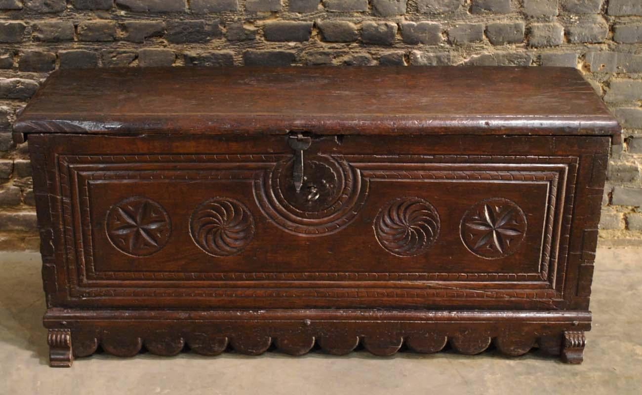 A beautiful trunk or coffer from Northern Spain that was made in the first part of the 17th century.
It features a rectangular hinged molded top over a deeply carved base. The front of the chest has five geometric circular carvings surrounded by a