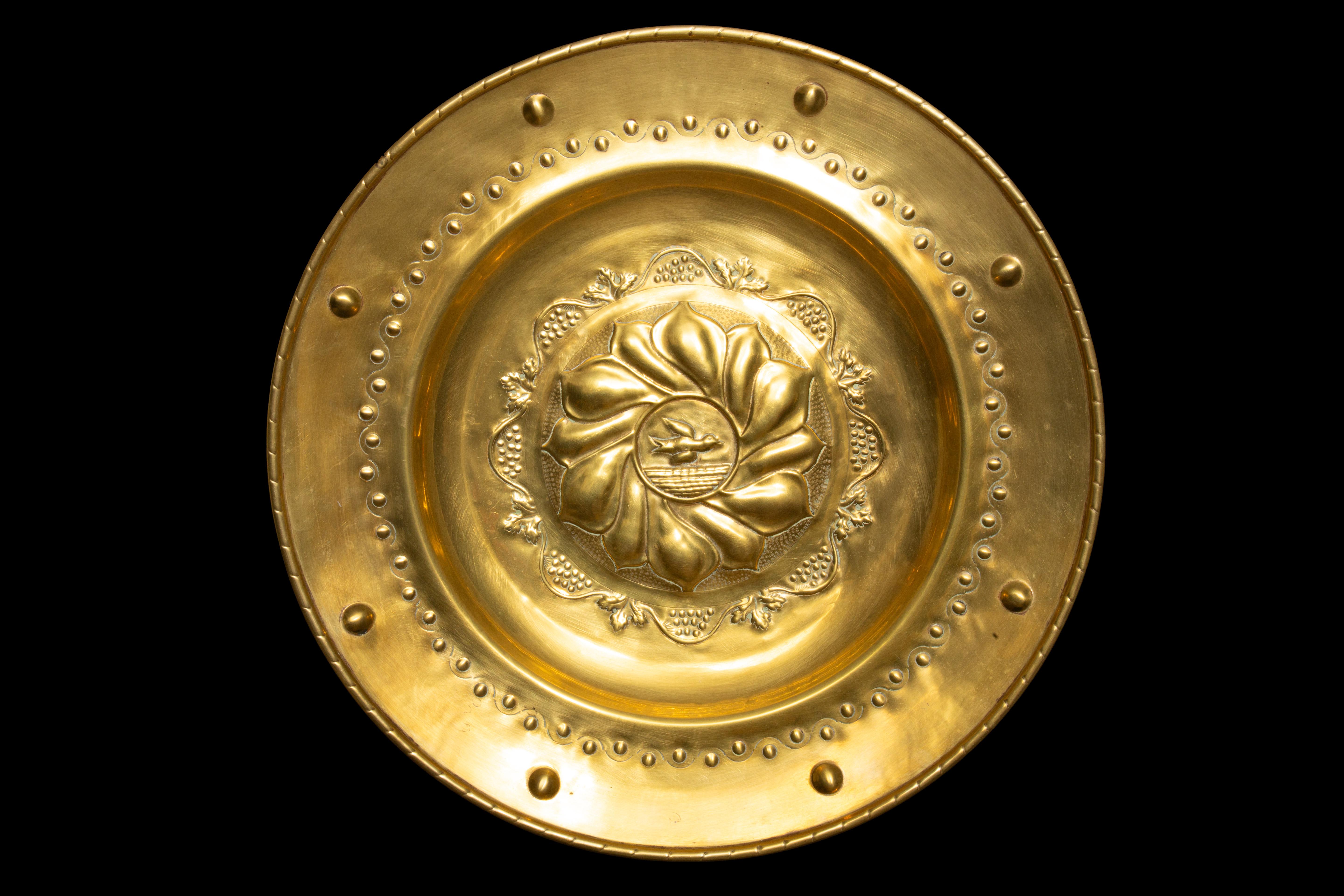 Exquisite 19th-century English ornamental brass alms dish, meticulously crafted to serve as a captivating vessel for collecting offerings from congregations. This remarkable piece, measuring an impressive 21.75 inches in diameter, features an
