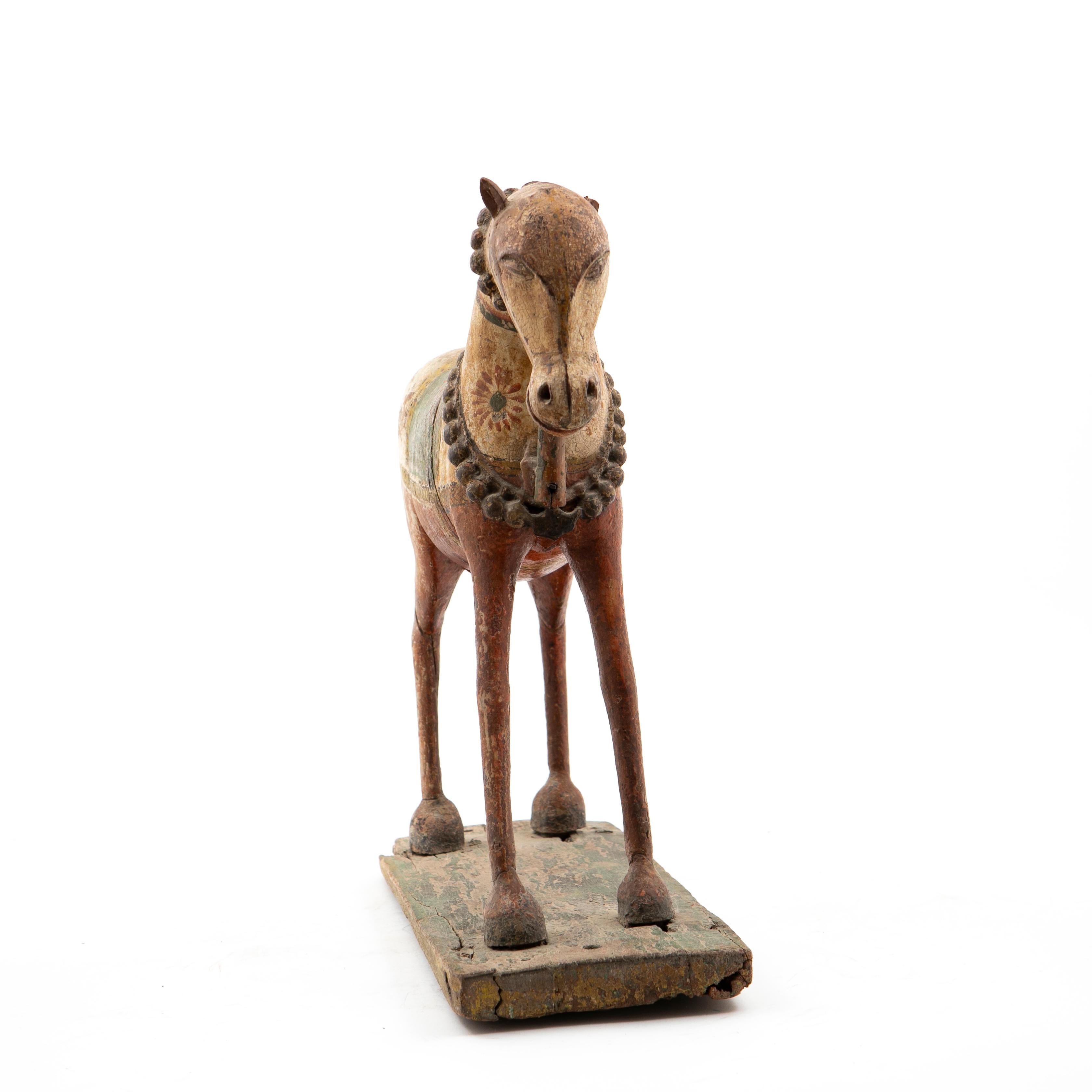 A Indian 18-19th century hand-carved wooden horse decorated with polychrome colors.
In original untouched condition with a beautiful age-related patina, showing the antique authenticity of this piece.

Very charming. One ear is missing.
India,