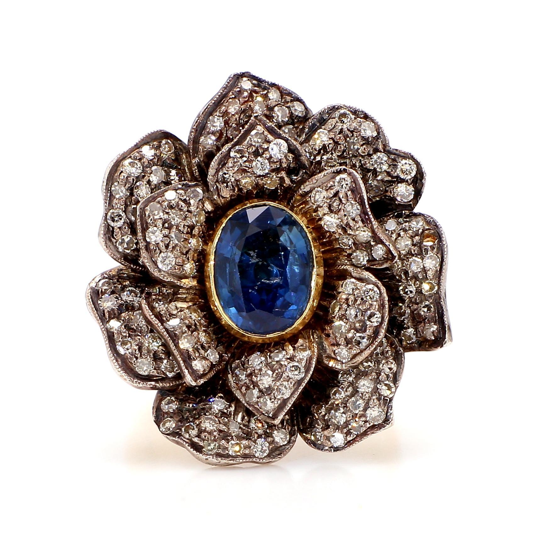 Discover the allure of the Sapphire Diamond Ring. This exquisite piece showcases a captivating 1.8 carat oval blue sapphire, known for its vibrant hue and elegant cut. The sapphire, set at the heart of the design, draws the eye with its deep,