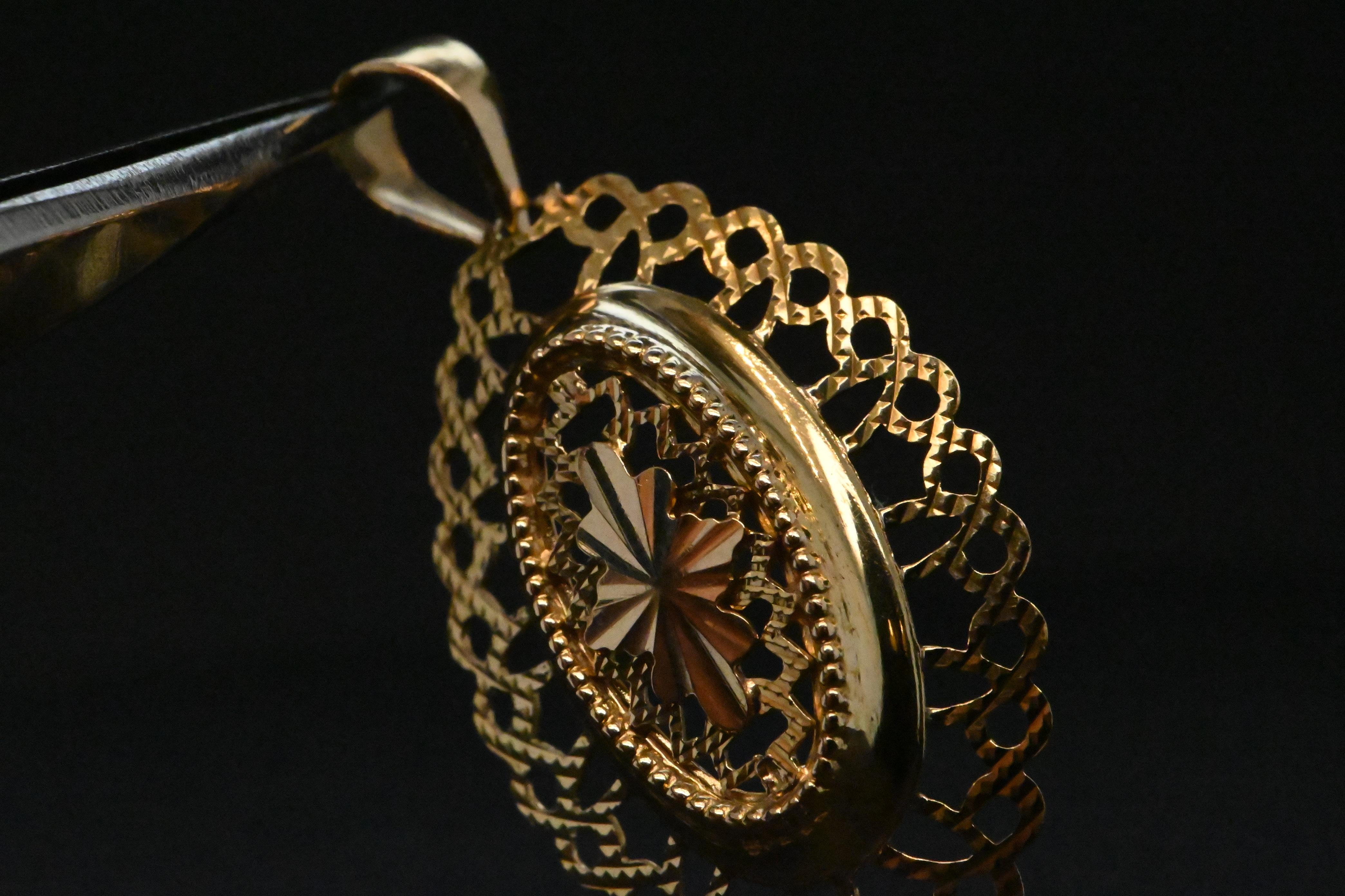 Questo pendente del XIX secolo in oro a 18 carati è un vero e proprio oggetto da collezione. Di forma ovale e finemente traforata, offre un design raffinato che cattura l'eleganza della sua epoca. 

Nel cuore di questo medaglione, i raggi accolgono