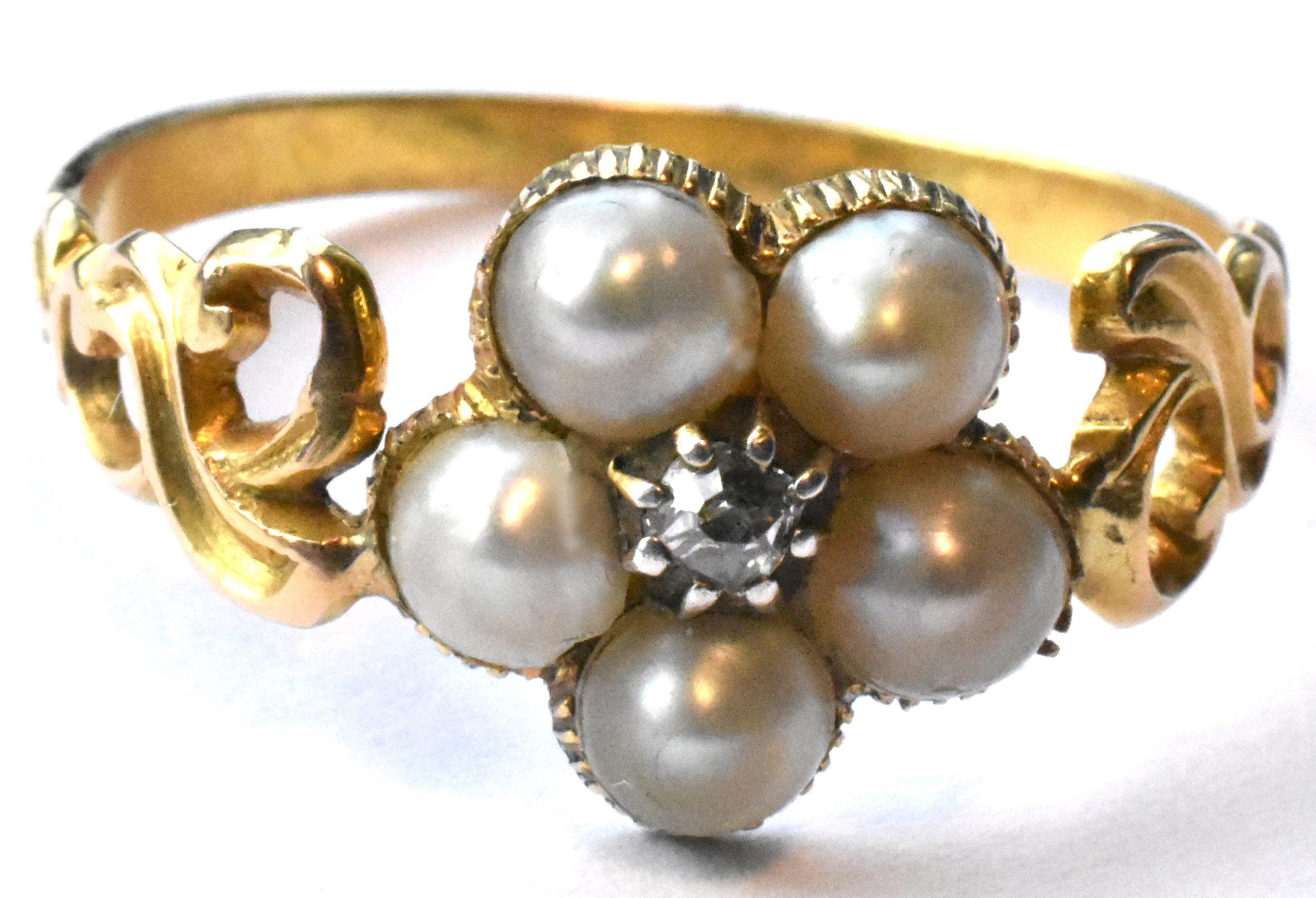 Beautiful feminine Georgian era 18 k cluster ring adorned with natural pearls and a rose cut diamond at its center. Pearls have a beautiful luster and the gold band of the ring is beautifully wrought in an open scrollwork pattern with incising, 