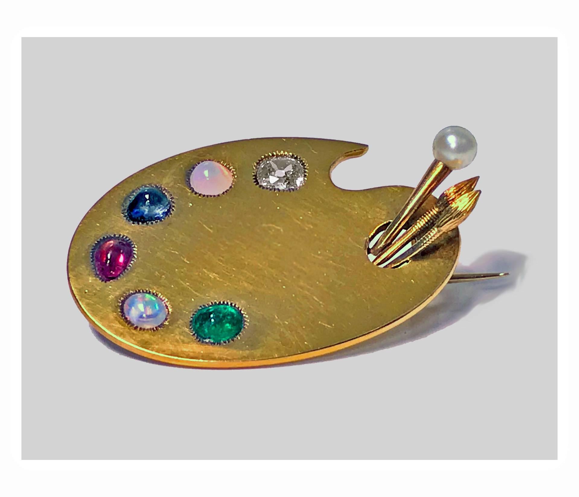 Antique 18-karat custom artist’s paint palette and tools brooch, circa 1900. The brooch of curvilinear form and accented with six individually milligrain collet set gemstones: old cushion cut diamond, approximately 0.30-carat, cabochon ruby,