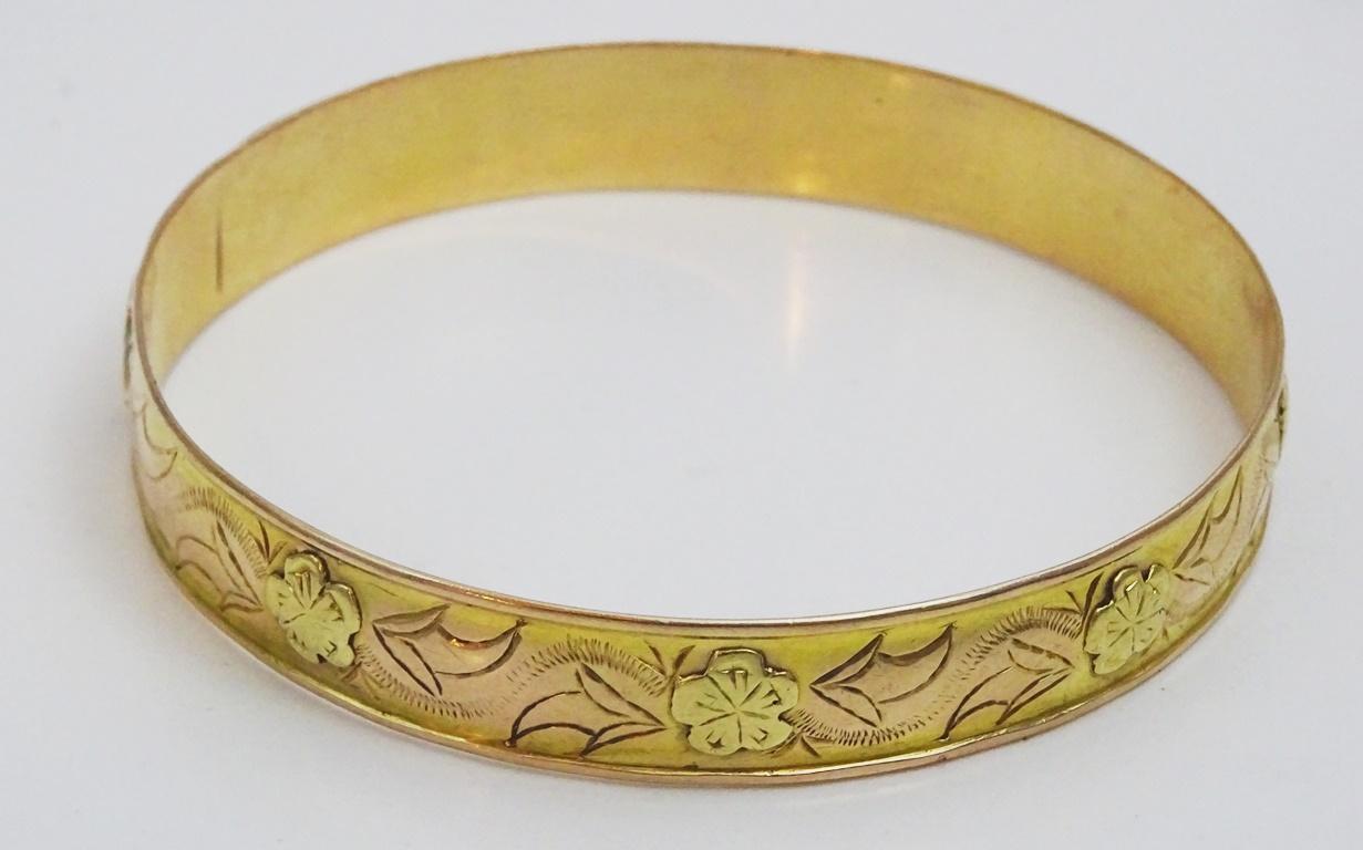 This antique 18 karat has no marks and has been acid tested for 18 karat Gold. 
Its origin is European from the beginning of the 20th century.
The style is reminiscent of Victorian bracelets , 
Delicate Floral Engravings  on yellow gold .highlighted