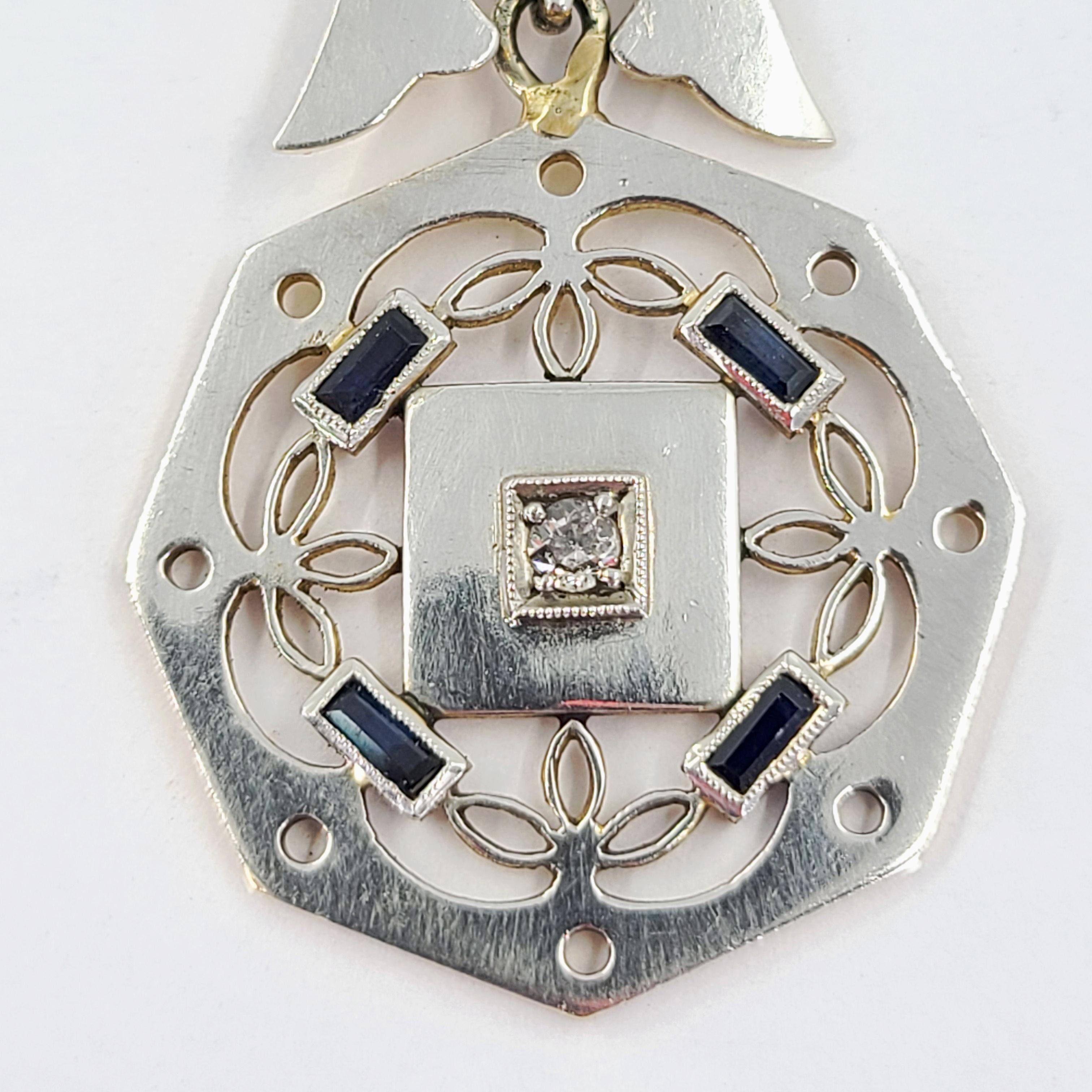 Antique 18 Karat White & Yellow Gold Watch Fob Featuring 1 Old Mine Cut Diamond Weighing 0.05 Carats & 4 Baguette Cut Sapphires Totaling 0.10 Carats. Finished Weight Is 11.4 Grams. 5.25 Inches Long.