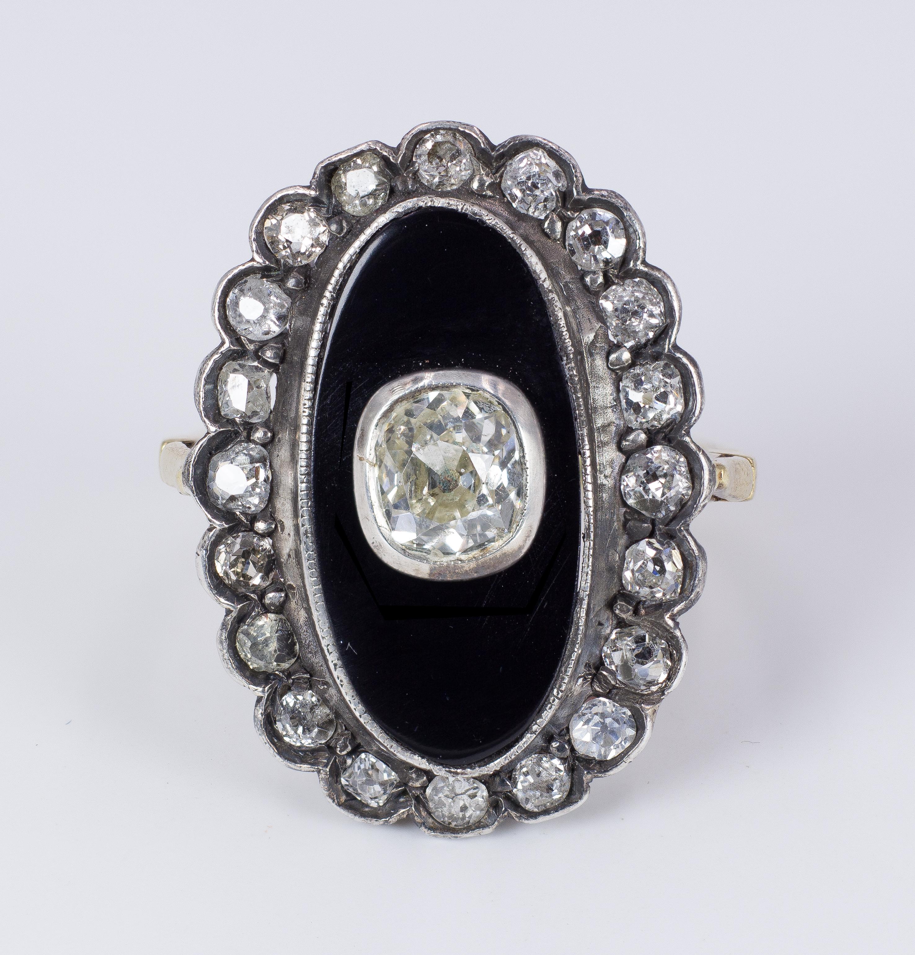 This incredible antique ring, dating from the early 20th Century, features a central onyx panel, set with a beautiful old cut mine diamond; the onyx is surrounded by a halo of rose cut diamonds, set in a lovely wavy mount. 
The diamonds are for a