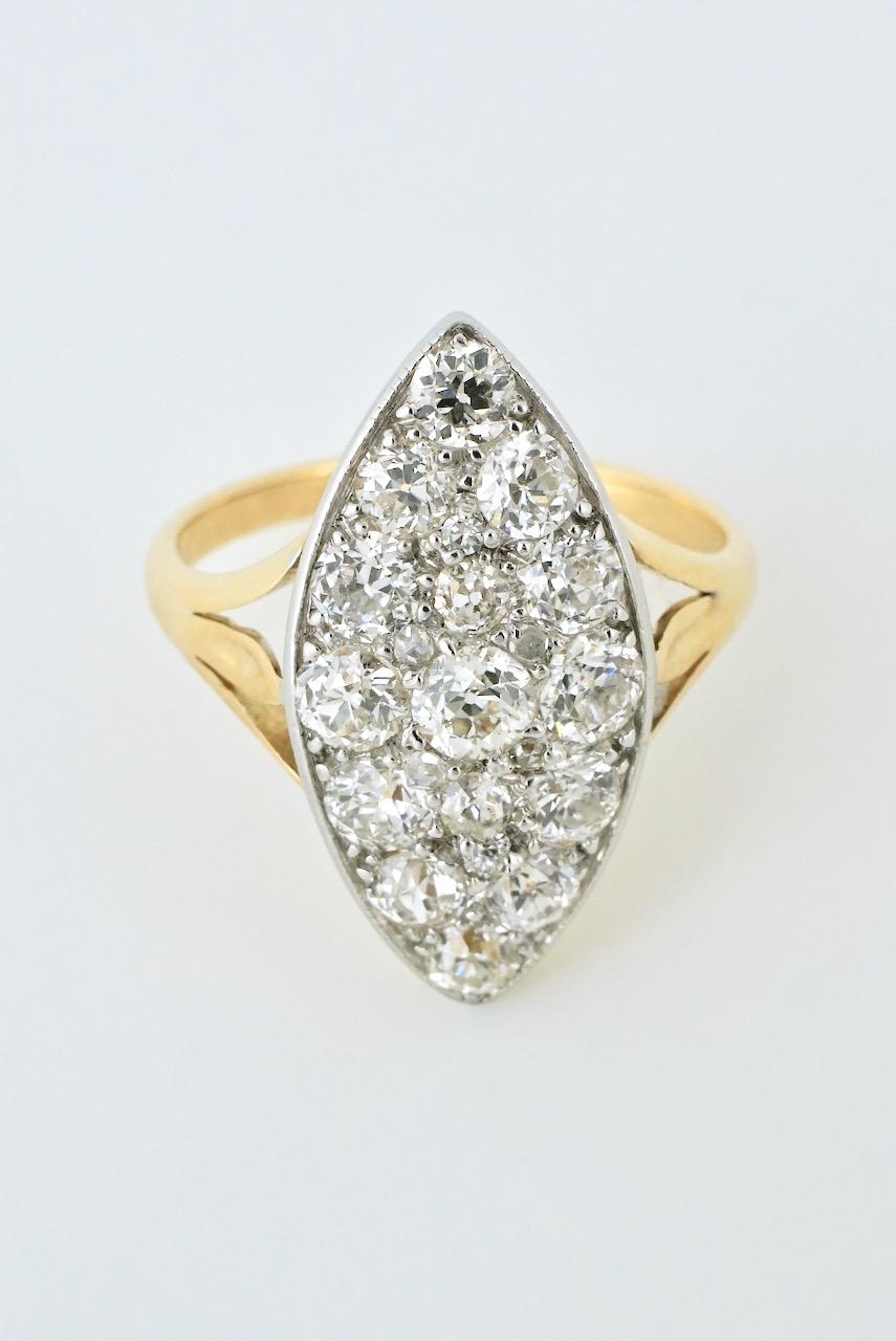 An antique 18k diamond marquise shape cluster ring consisting of 15 old cut diamonds pave set in platinum to form a domed marquise shape plaque and mounted on an 18k yellow trifurcated shank - a wonderfully dense pave set ring that really sparkles