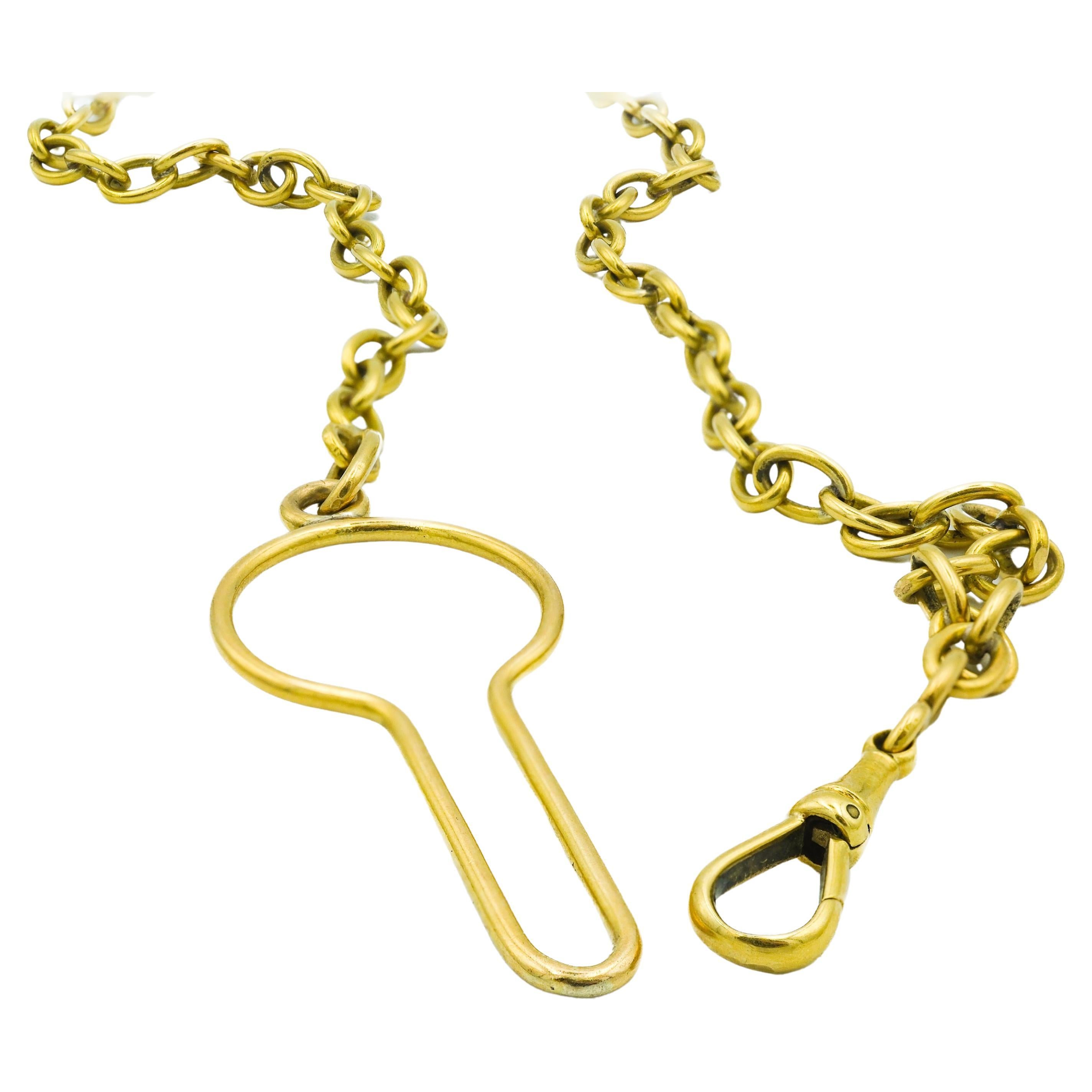 This 18 karat yellow gold chain exemplifies Victorian era jewelry design, characterized by its functionality and craftsmanship. The piece features a dog clasp, commonly used in the period to secure a gentleman's pocket watch. Its distinctive