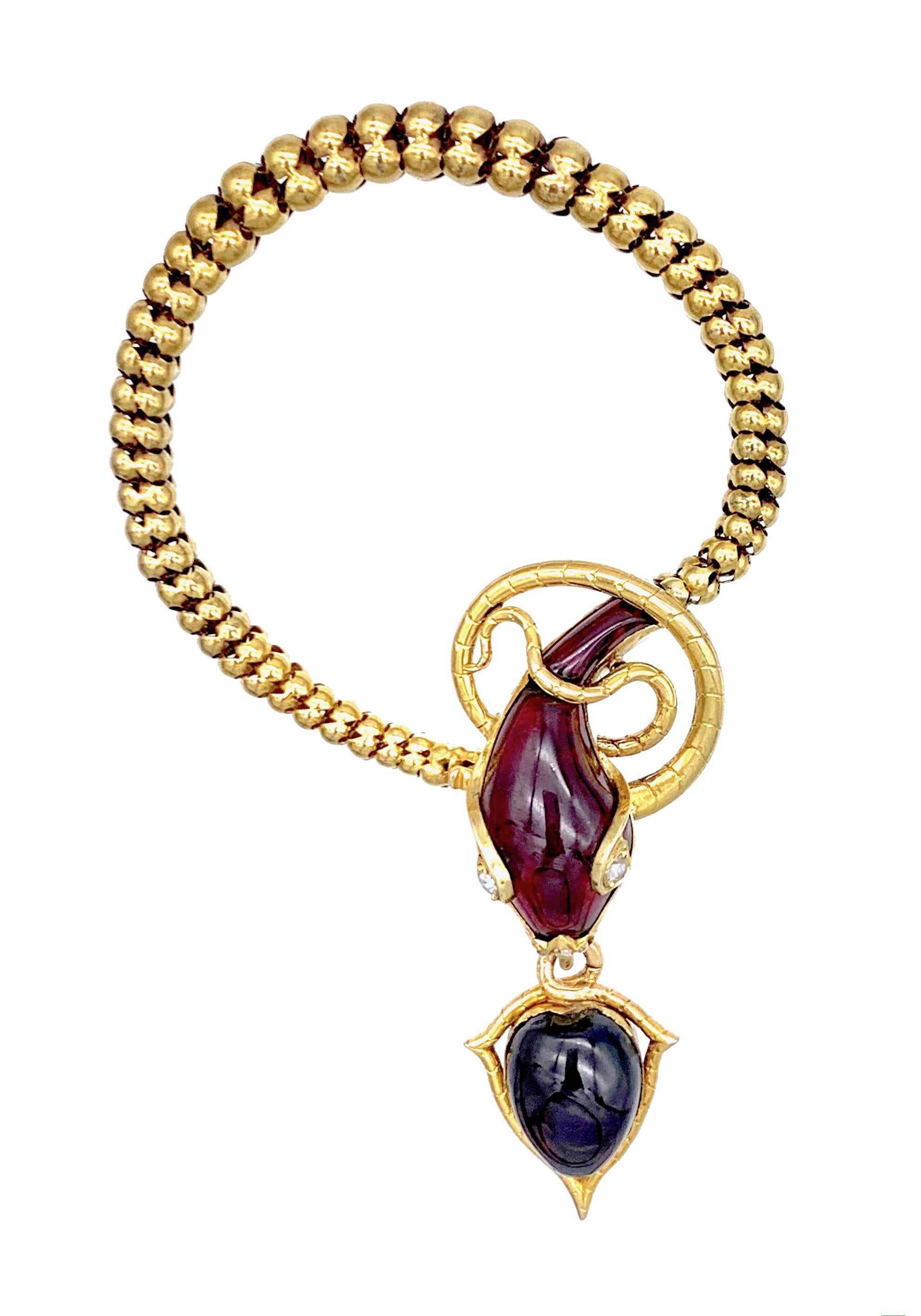Dieses außergewöhnliche Schlangenarmband mit Medaillon wurde um 1850 in Handarbeit aus 18 Karat Gold gefertigt. Der Kopf der Schlange und ein Teil ihres Körpers sind mit einem aus einem Stück Almandin geschliffenen Granatcabochon besetzt. Das