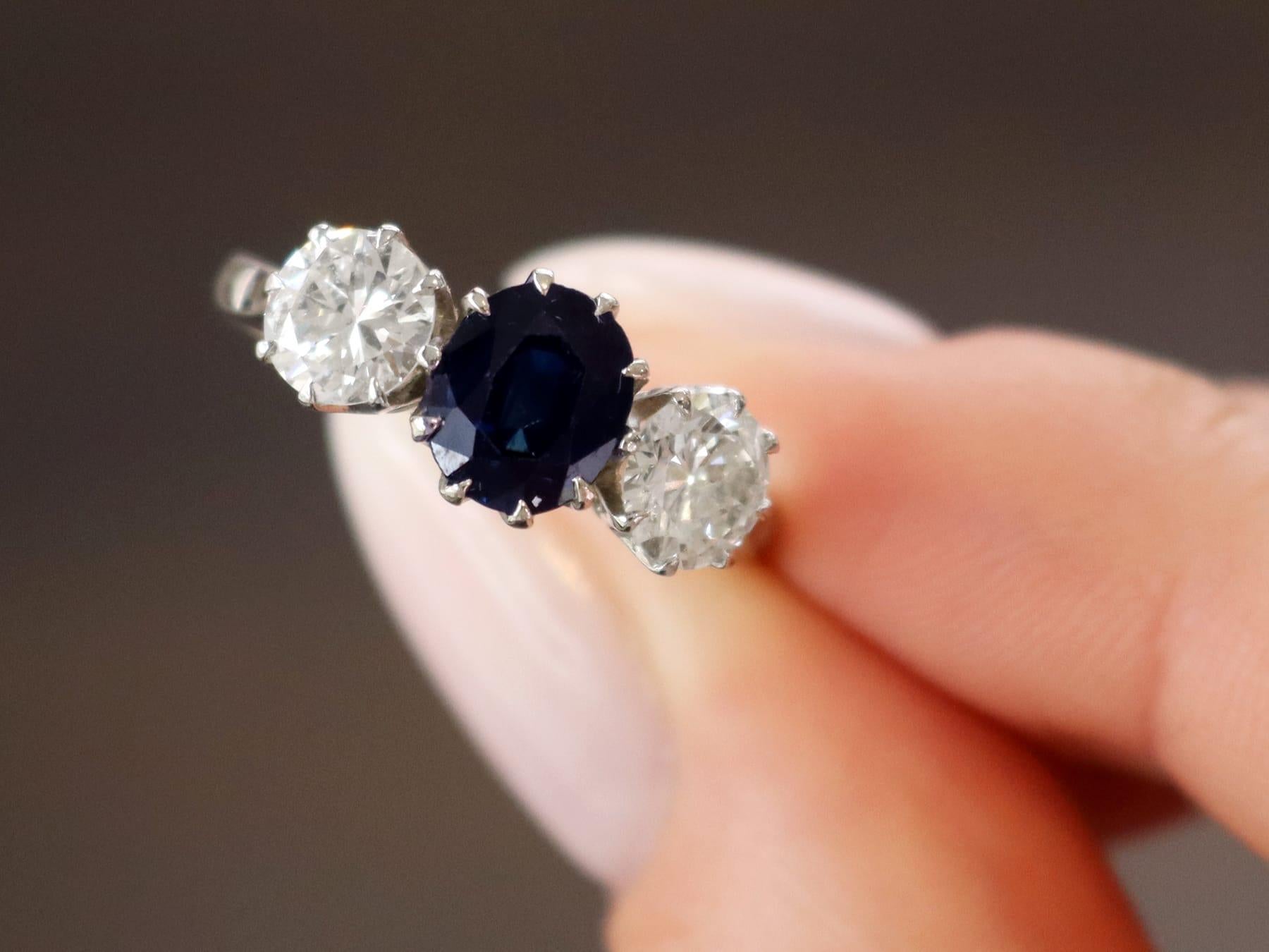 Une bague trilogie en or blanc 18 carats, avec un saphir de 1,80 carat et un diamant de 1,35 carat. Elle fait partie de nos diverses collections de bijoux anciens et de bijoux de succession.

Cette étonnante, fine et impressionnante bague ancienne