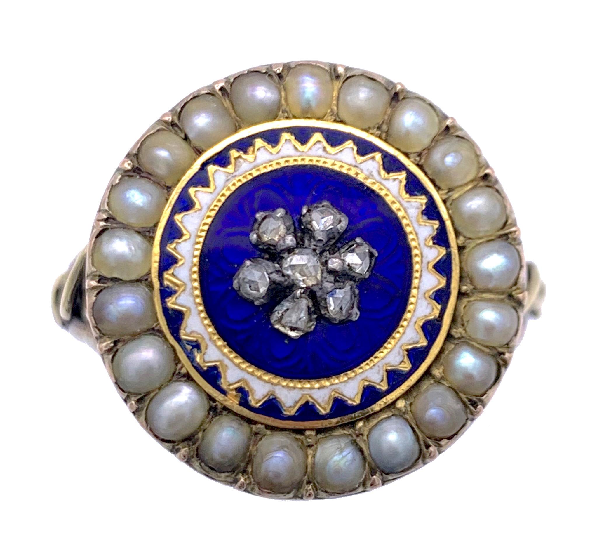 This elegant and rare Georgian dress ring features, on a translucent blue enamelled background, a flower made out of seven rose diamonds within a stylised sun.  A gold disk, covered with royal blue enamel is decorated with white enamelled sun rays