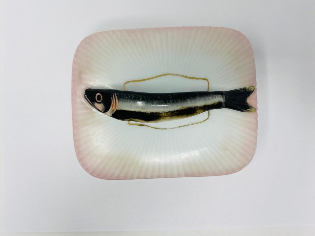 Rare boîte à couvercle en porcelaine autrichienne de l'époque victorienne à poignée en forme de sardine.
La boîte a un motif nervuré, tout blanc, avec de l'or autour de la base et du couvercle.
L'anse est une sardine et repose sur un couvercle