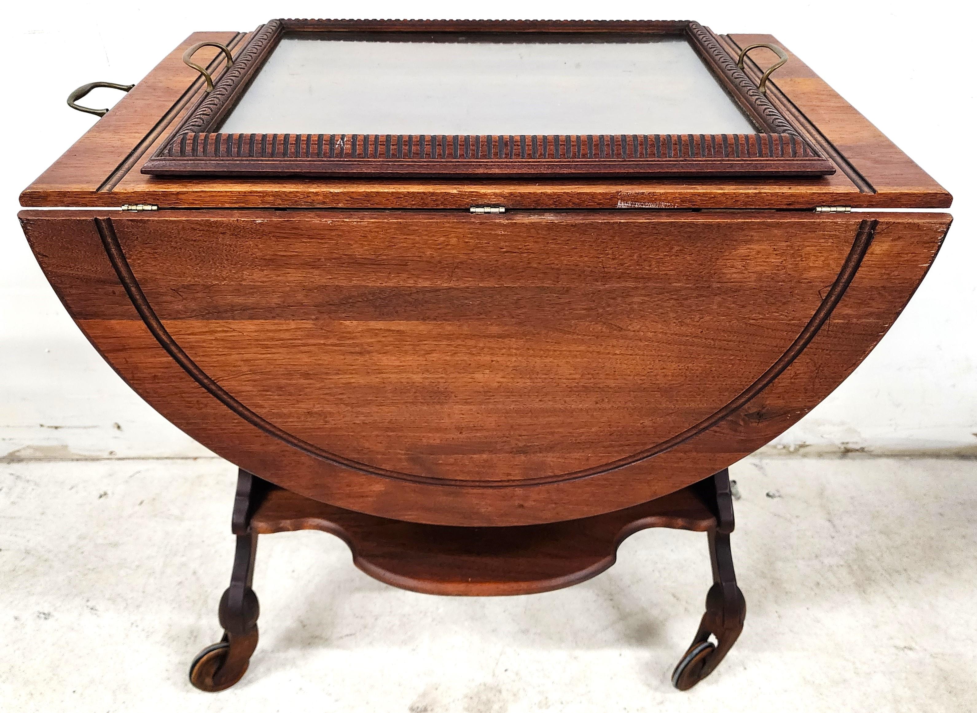 For FULL item description click on CONTINUE READING at the bottom of this page.

Offering One Of Our Recent Palm Beach Estate Fine Furniture Acquisitions Of An
Antique 1800s Drop Leaf Serving Cart Sideboard Rolling with Original Glass Serving
