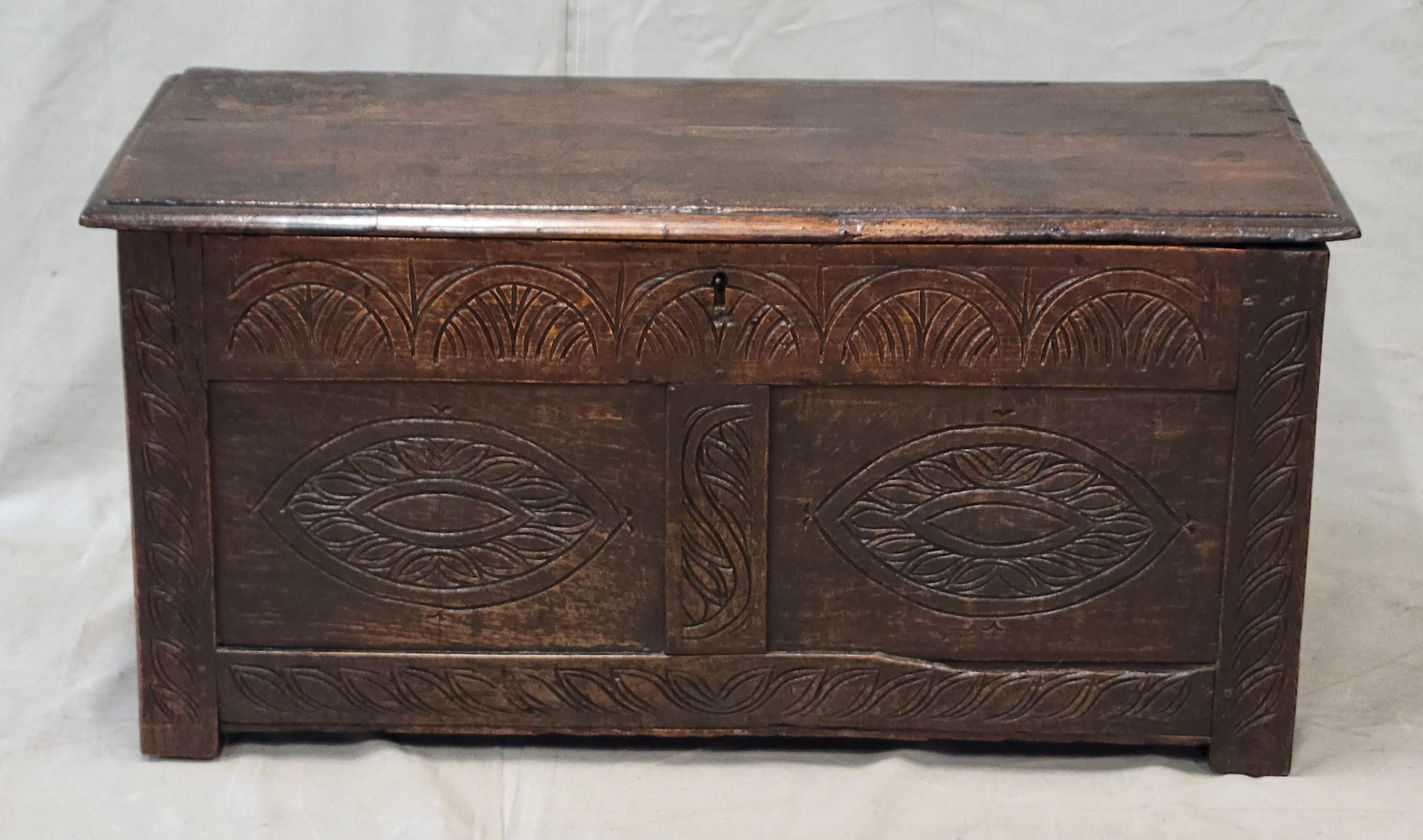 A beautiful, classic 19th century English carved oak storage trunk or coffer. Incised decorative carved patterns in the front. It could be used as a coffee table, at the foot of a bed for storage, or in a hallway or entryway for seating and storage.