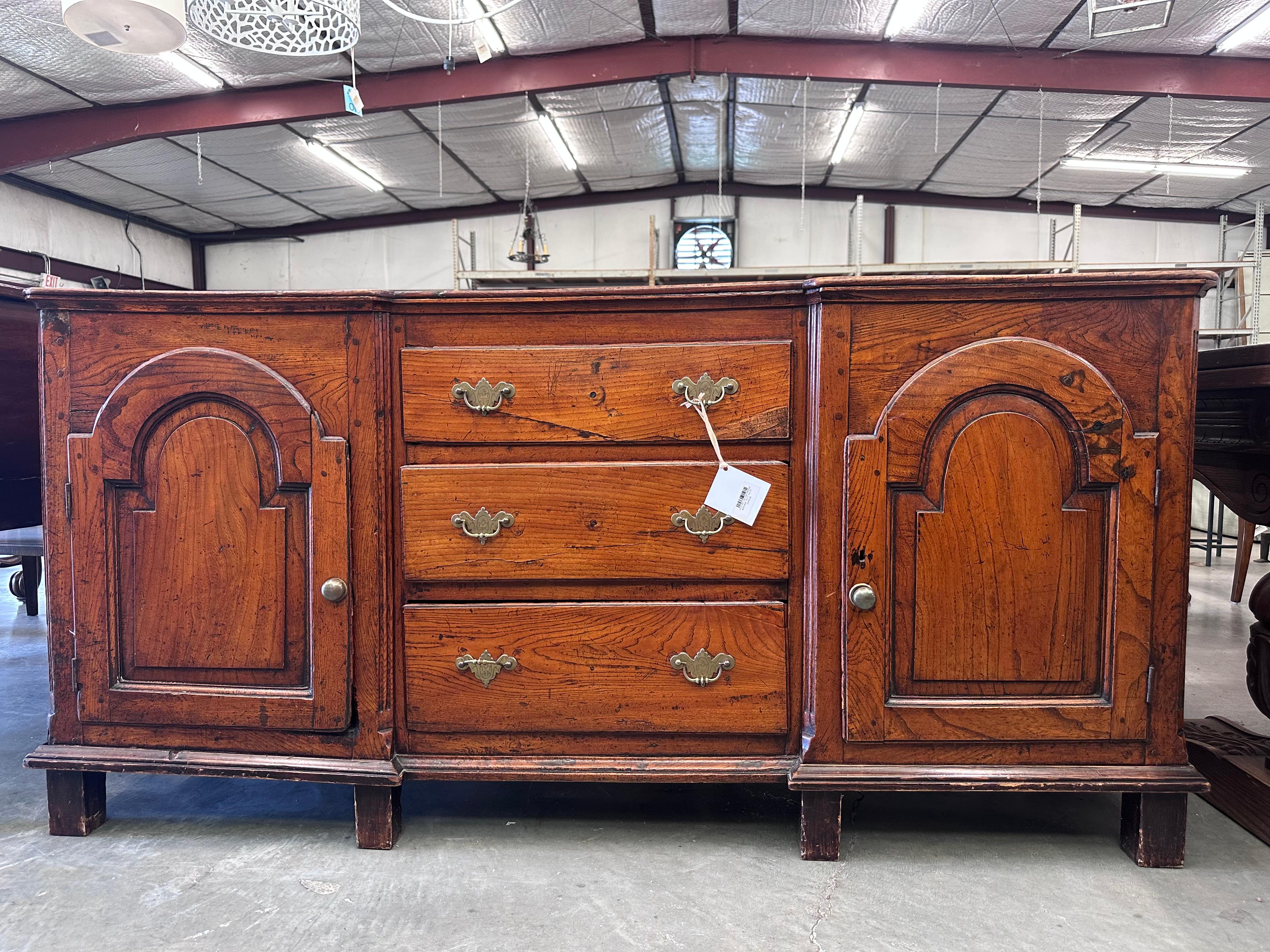Si tratta di un antico comò o credenza in Oak, probabilmente risalente alla fine del XVIII o all'inizio del XIX secolo, forse di origine inglese. Il pezzo è realizzato in rovere massiccio con una patina ricca e calda che mette in evidenza le