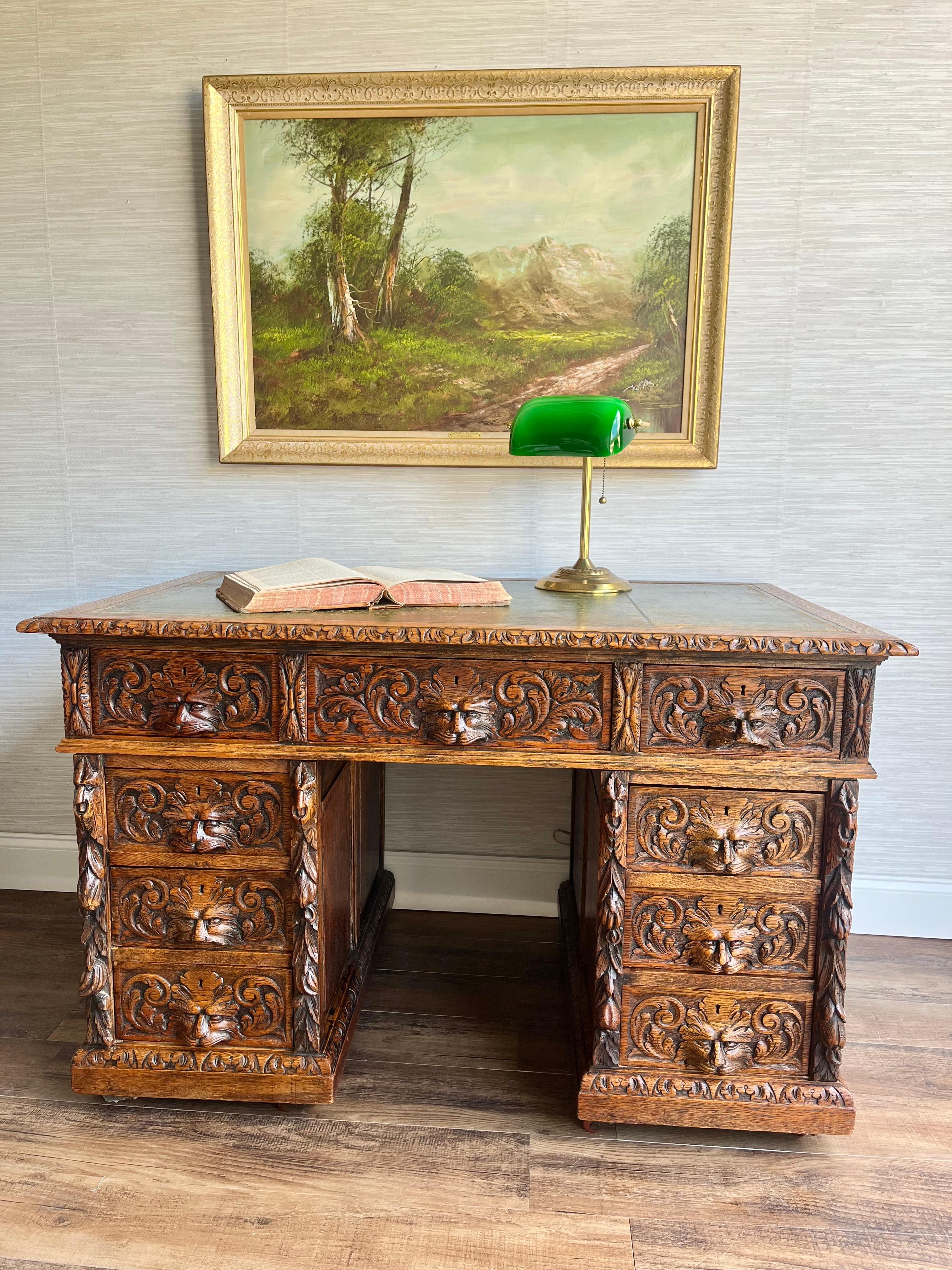 Presenting an exquisite antique piece hailing from England, this solid oak desk showcases timeless craftsmanship and an air of distinguished elegance. Its rectangular top, with a touch of vintage charm, features a tooled worn green leather insert,