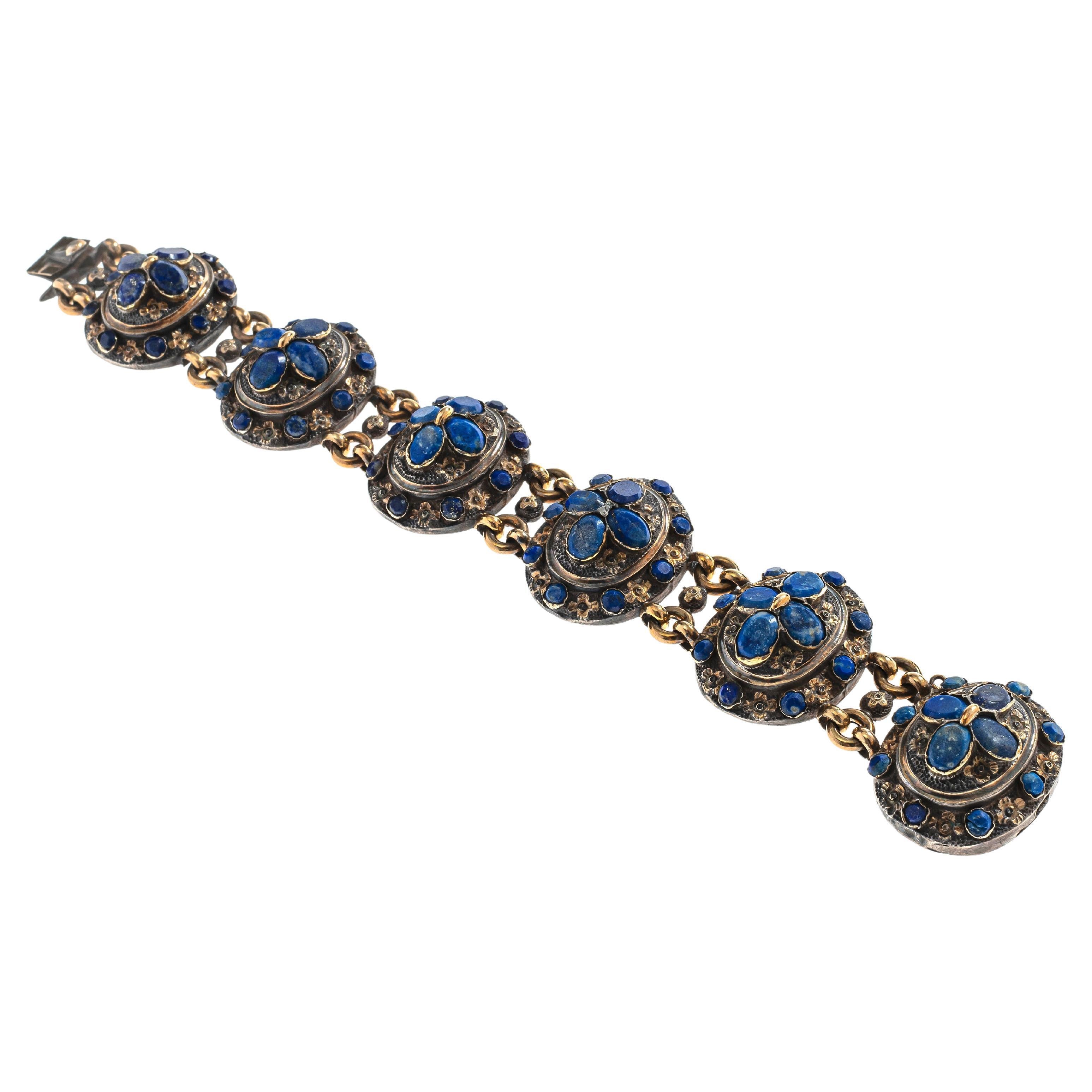 Dieses bedeutende vergoldete Silberarmband ist im neugotischen Stil ausgeführt, der in Frankreich in den 1840er Jahren beliebt war. Das Armband besteht aus sechs ovalen, gelenkig angeordneten Elementen in Hochrelief. Jedes Element hat ein inneres