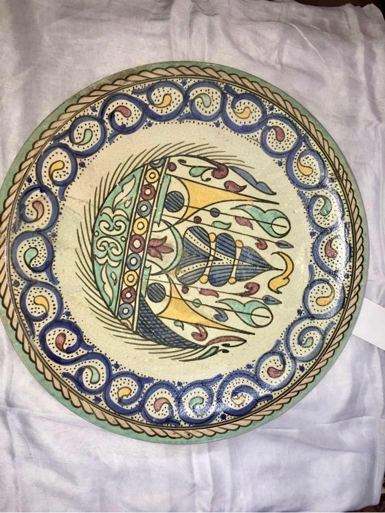 This antique Moroccan plate was handcrafted in the Northern Moroccan town of Fez. Entirely hand painted in a style unique to the area, showing significant Andalusian influence. While the back of the plate does have crazing, there are no cracks or