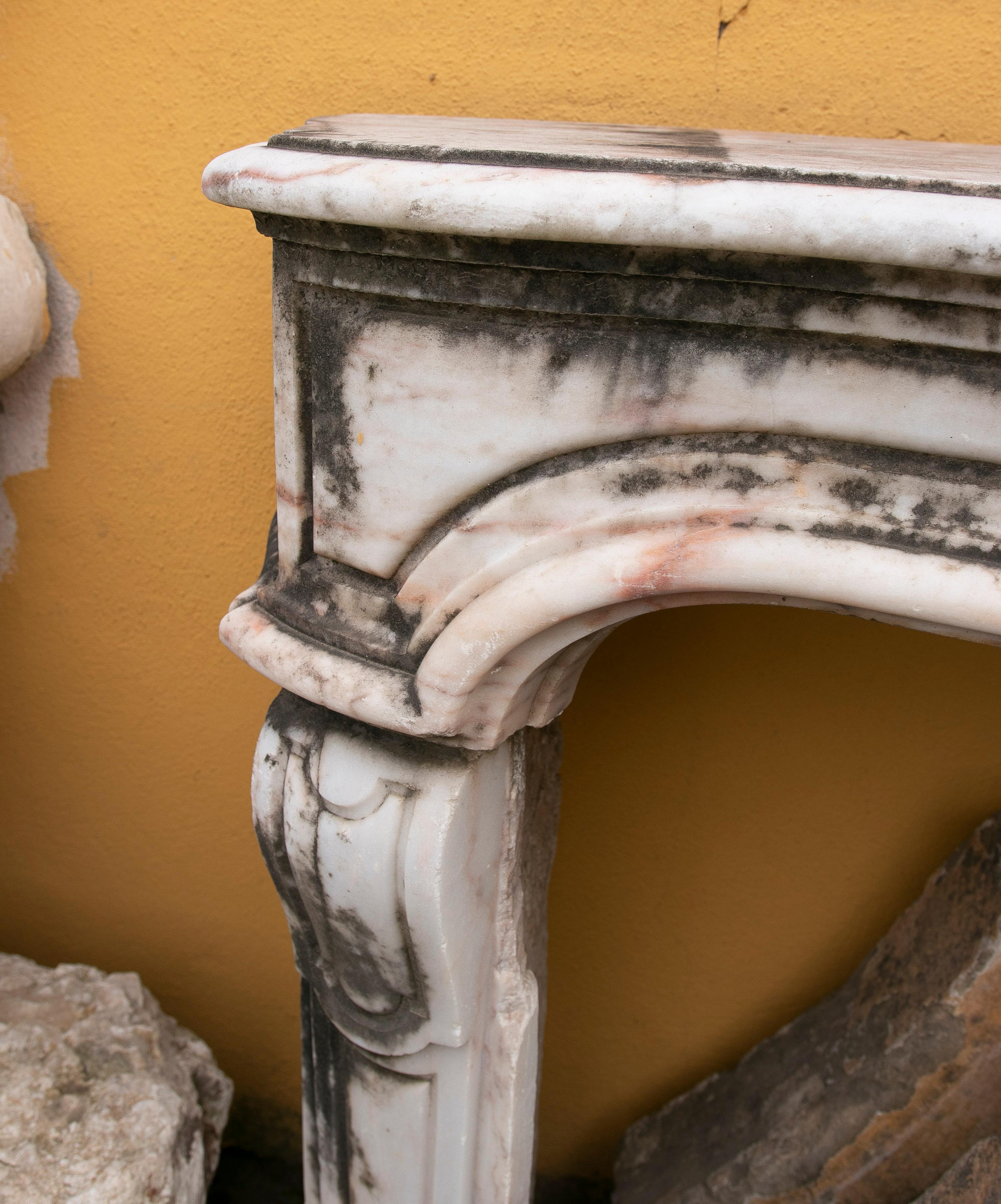Antique 1850s French neoclassical white marble fireplace mantle, composed of three solid parts, two pilaster legs and top mantel, with simple yet elegant panelled ornamentation. 

