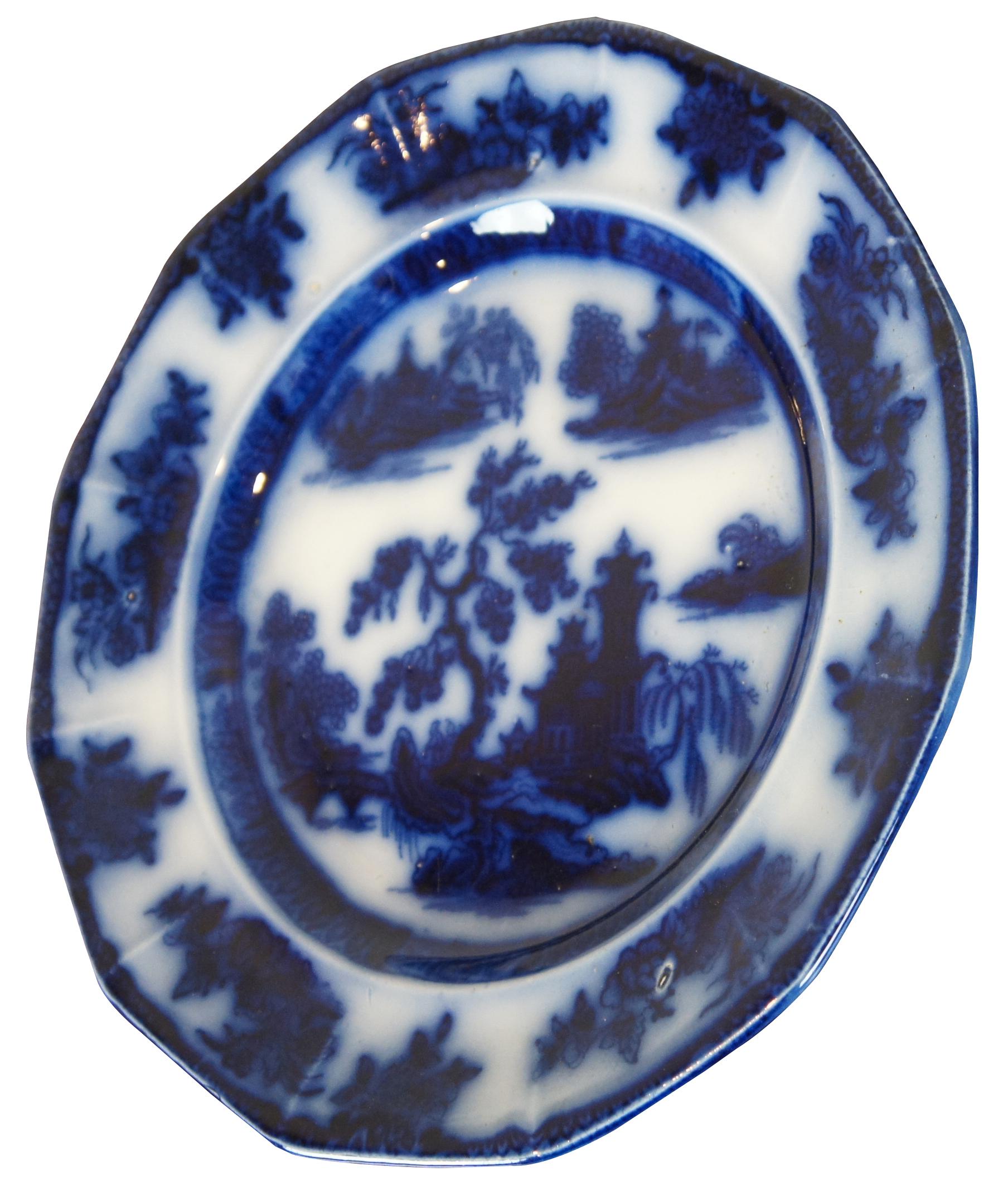 Antique circa 1850s Wedgwood Ironstone Chapoo flow blue porcelain plate with a design of flowers and a central chinoiserie landscape.
 
