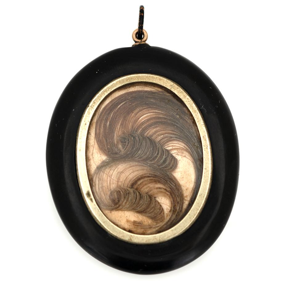 This deeply evocative Victorian mourning pendant is crafted from carved Whitby Jet, renowned for its lightness and mirror-like polish. The oval form is smooth and domed, highly reflective, and rich in colour—an excellent example of genuine Jet’s