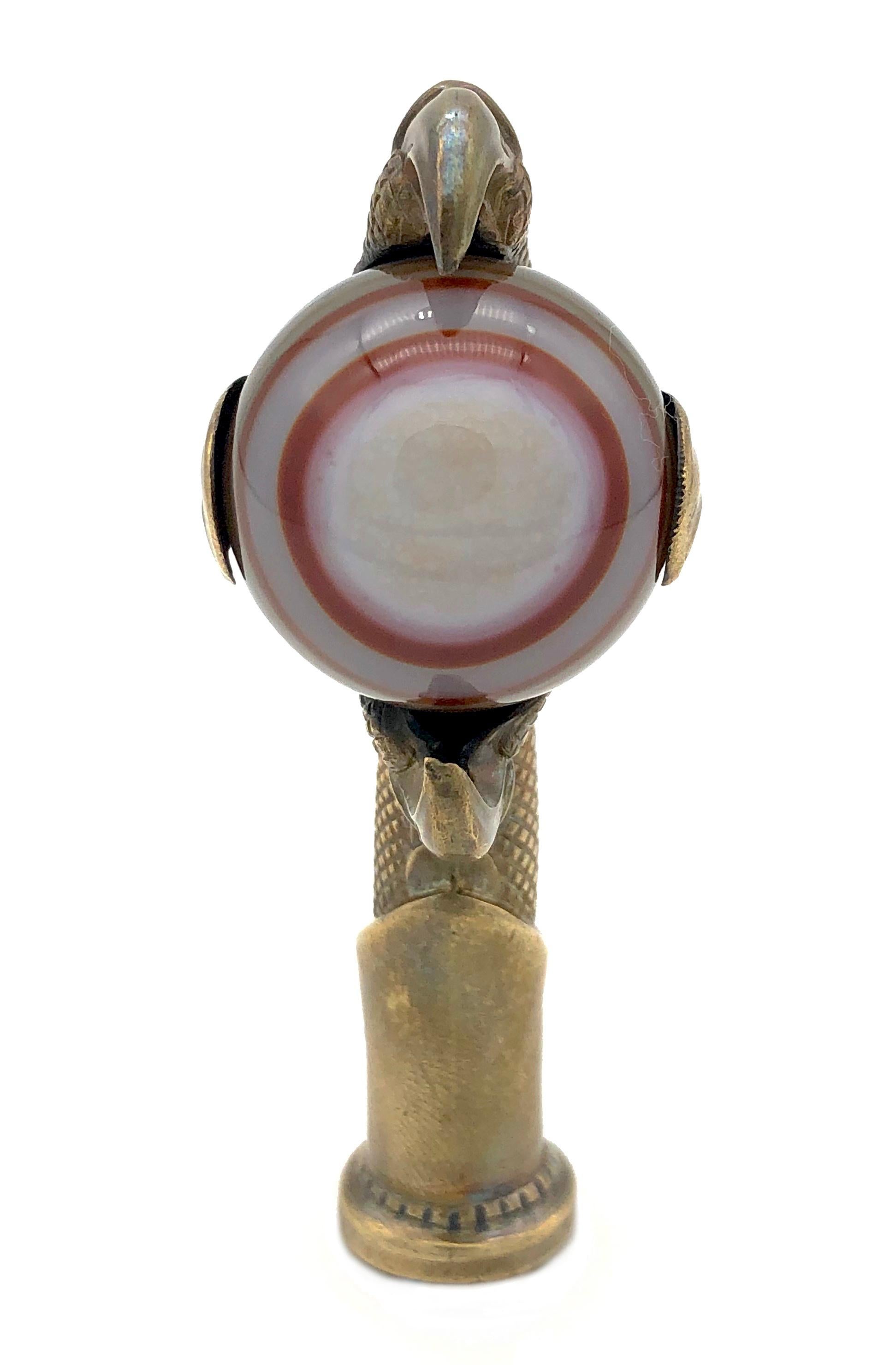 This beautifully modelled seal in the shape of a bird of prey 's claw holding a red beige and white banded agate ball has been made around 1870. 