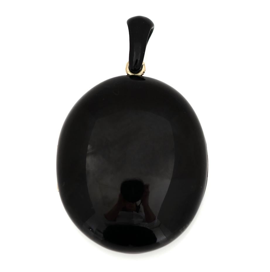 This striking Victorian mourning locket is carved from glossy Whitby Jet, a lightweight fossilised material prized for its intense black sheen. Oval in form, the piece is set with warm-toned brass fittings, a metal often used in mourning jewellery