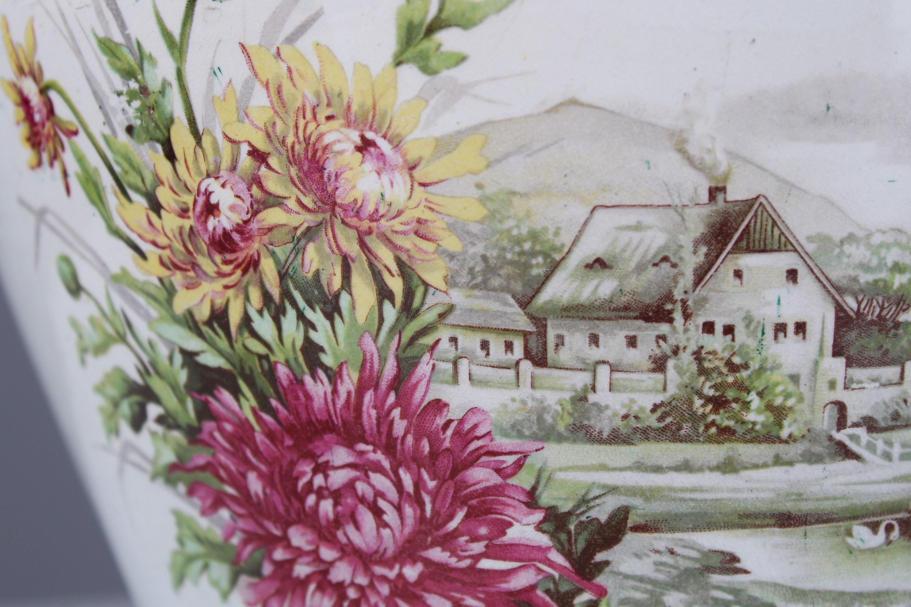 Beautifully crafted flower pot, France, 1880.
With a curved and gilded edging on the top.
The front shows a hand-painted country house with a pond in which two swans are swimming. Floral tendrils in pink and yellow frame the rural scene.


