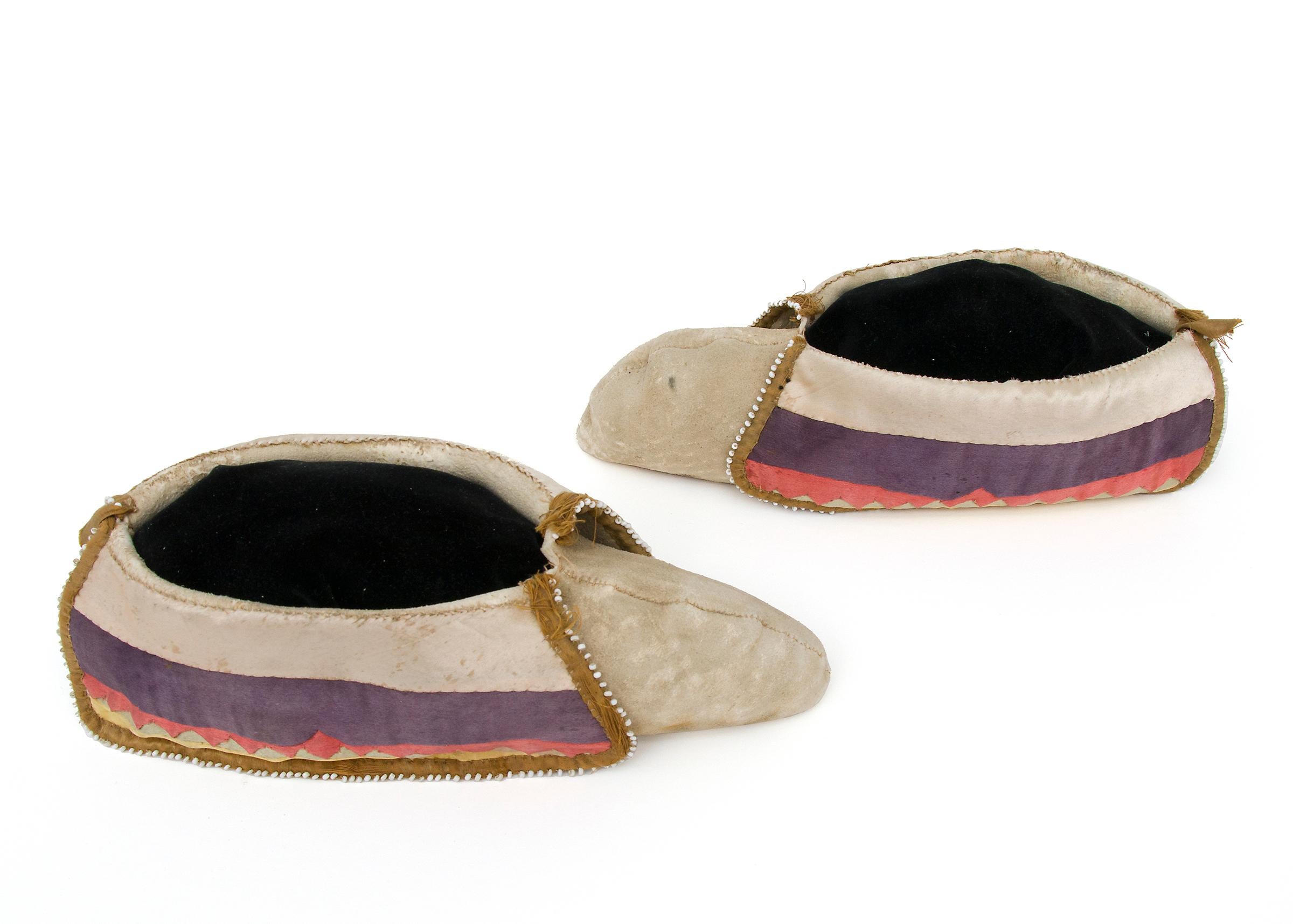 Este mocasín Potawatomi de hacia 1880 es un raro y excepcional ejemplo de la artesanía de los nativos americanos de los Bosques del Noreste, que muestra el arte de la tribu Potawatomi. Fabricados con piel curtida autóctona, estos mocasines presentan
