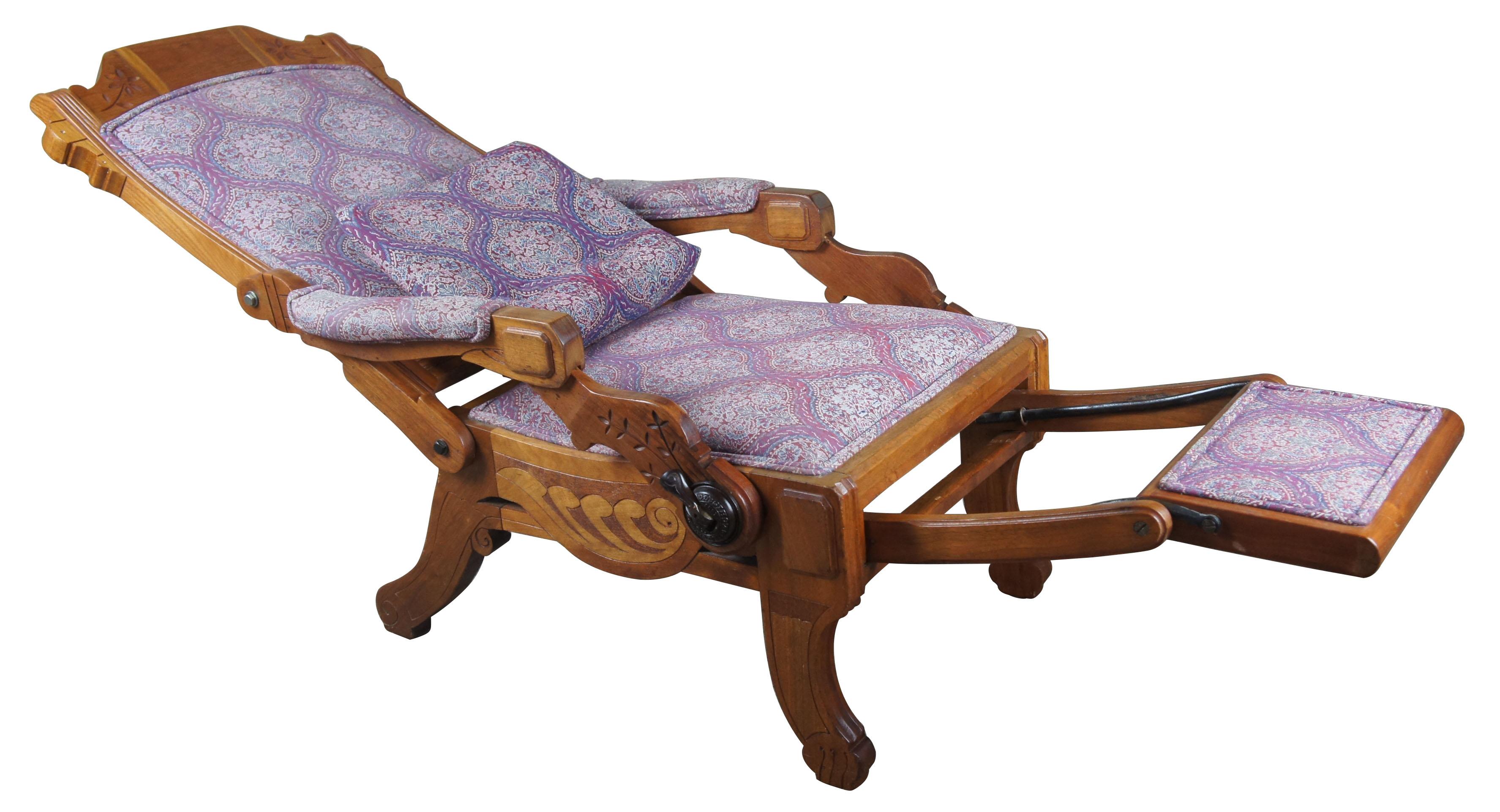 An American late 19th century walnut reclining armchair by the Hartley Reclining Chair Company of Chicago. Features carved and incised floral decorated frame with adjustable reclining back and pull-out footrest operated by a brass and steel