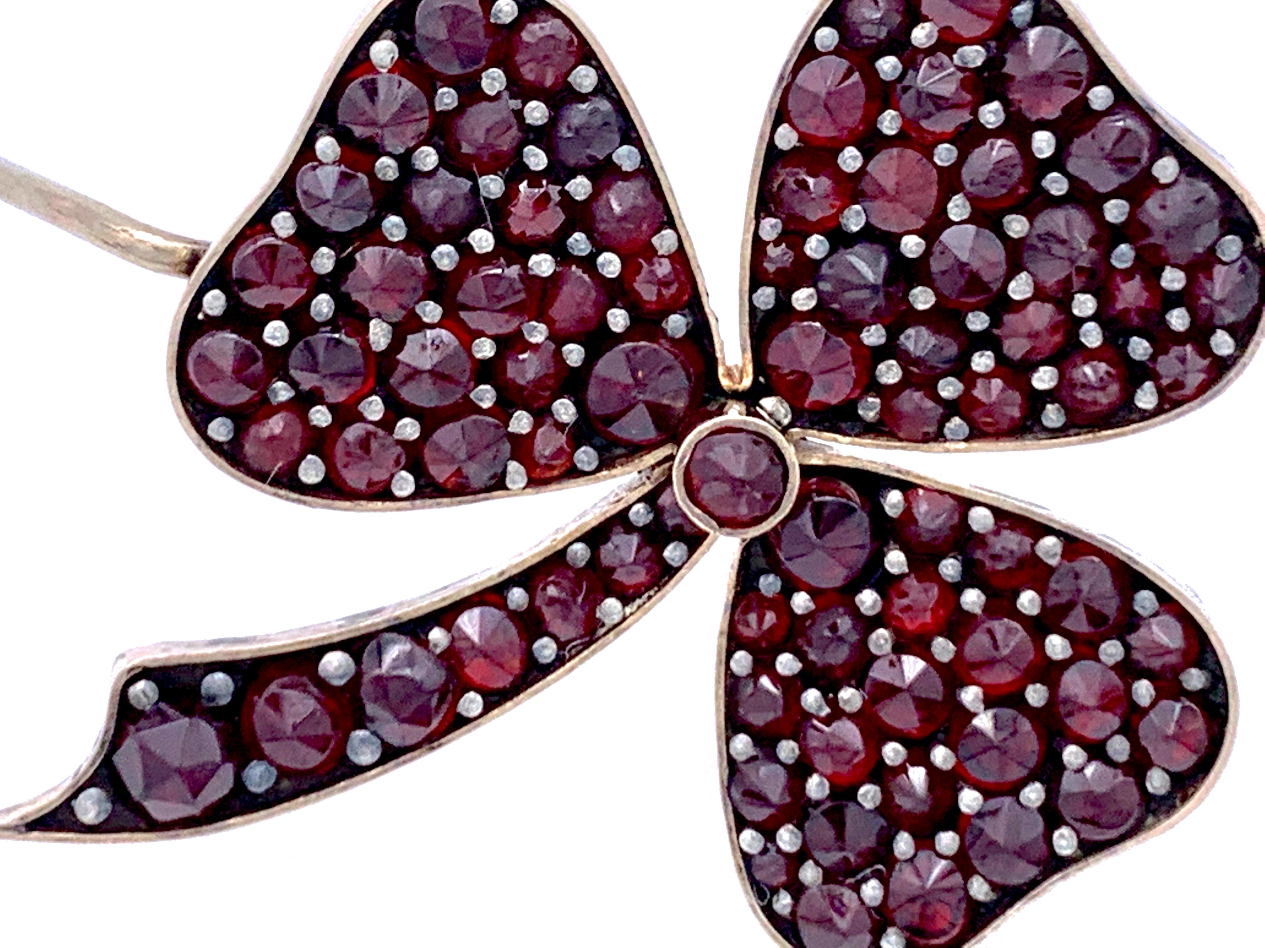 This brooch in the shape of a three leaf clover is set with bohemian garnets and was a gift for good luck. The garments are set in 9 karat gold.