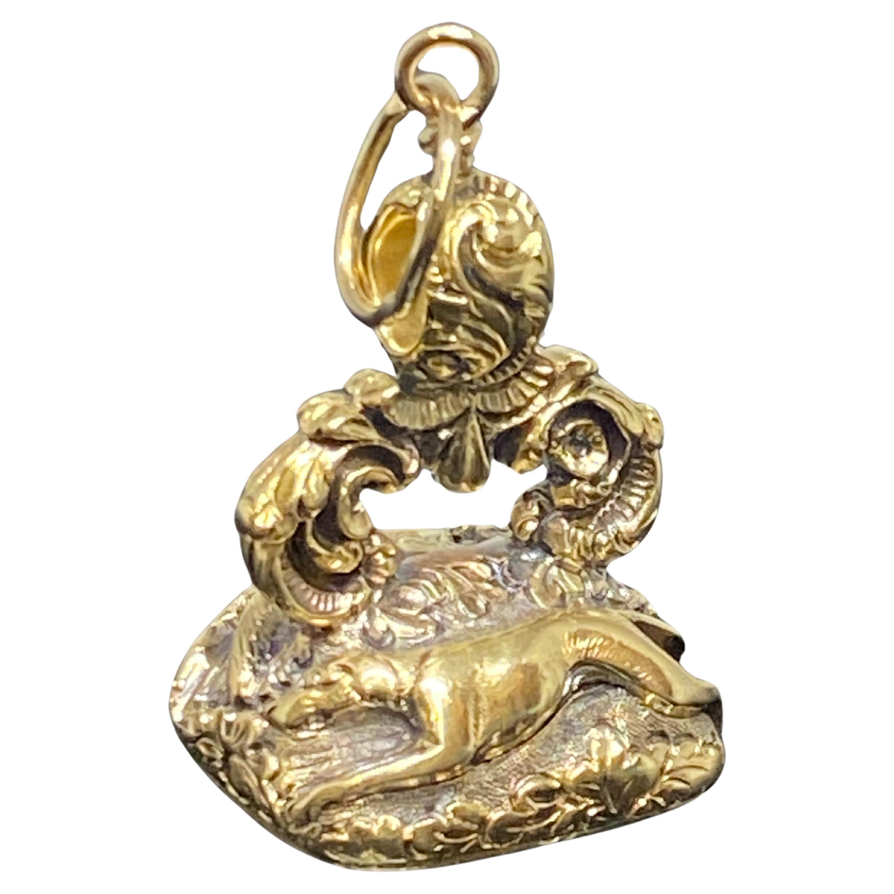 Beautiful antique Victorian fob (circa 1880s to 1900s) crafted in 14 karat yellow gold.  This charming fob features a fox on one side and a hound on the other chasing after another. The underside of the fob is engraved carnelian stone with detailed