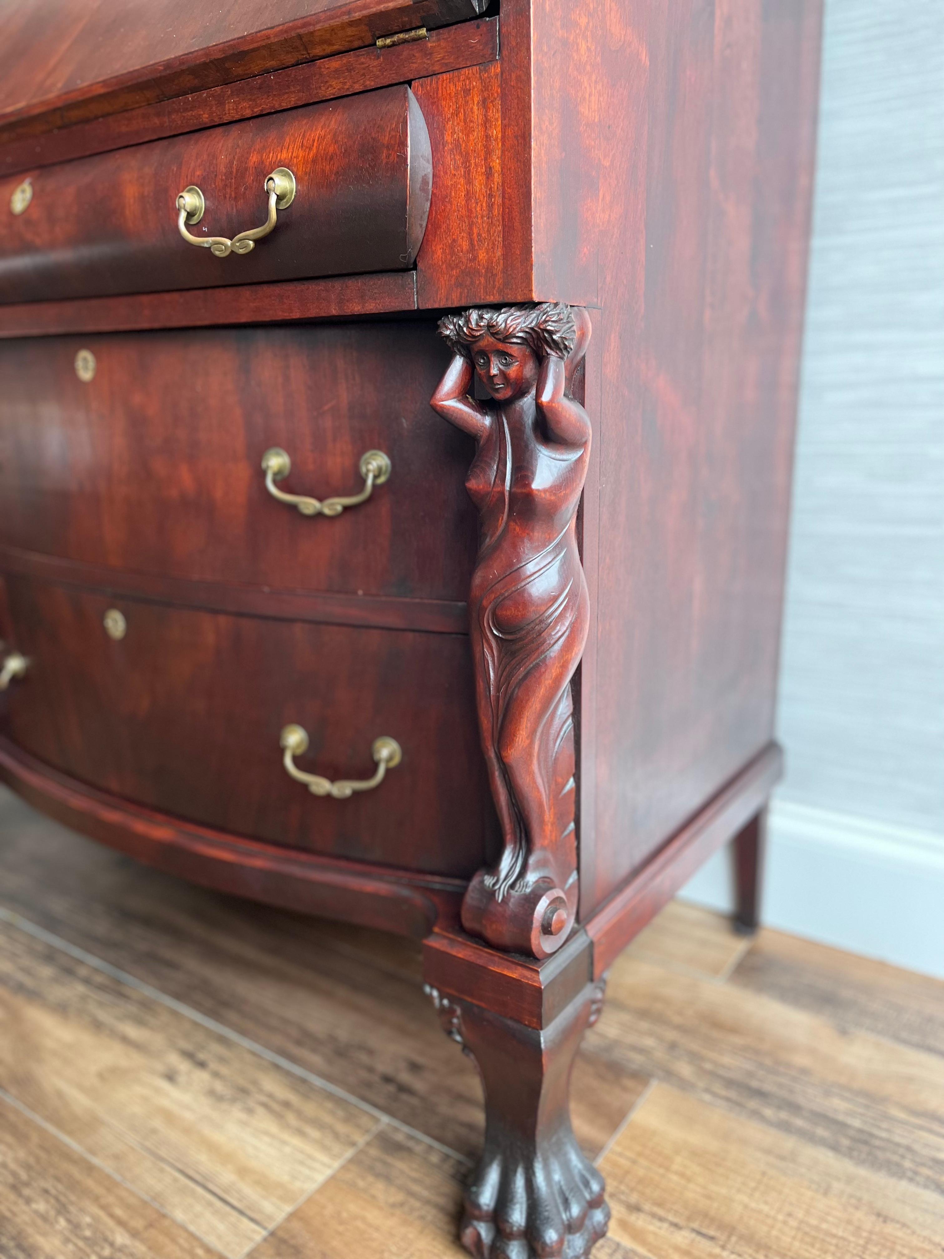Step into a narrative of art and history with our antique secretary desk, circa 1890, crafted from the sumptuous depths of mahogany. This rare Italian gem is adorned with hand-carved caryatids, ancient symbols of strength and beauty, bringing an air