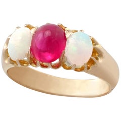 Antico anello a trilogia in oro giallo con rubino tagliato a cabochon e opale del 1890
