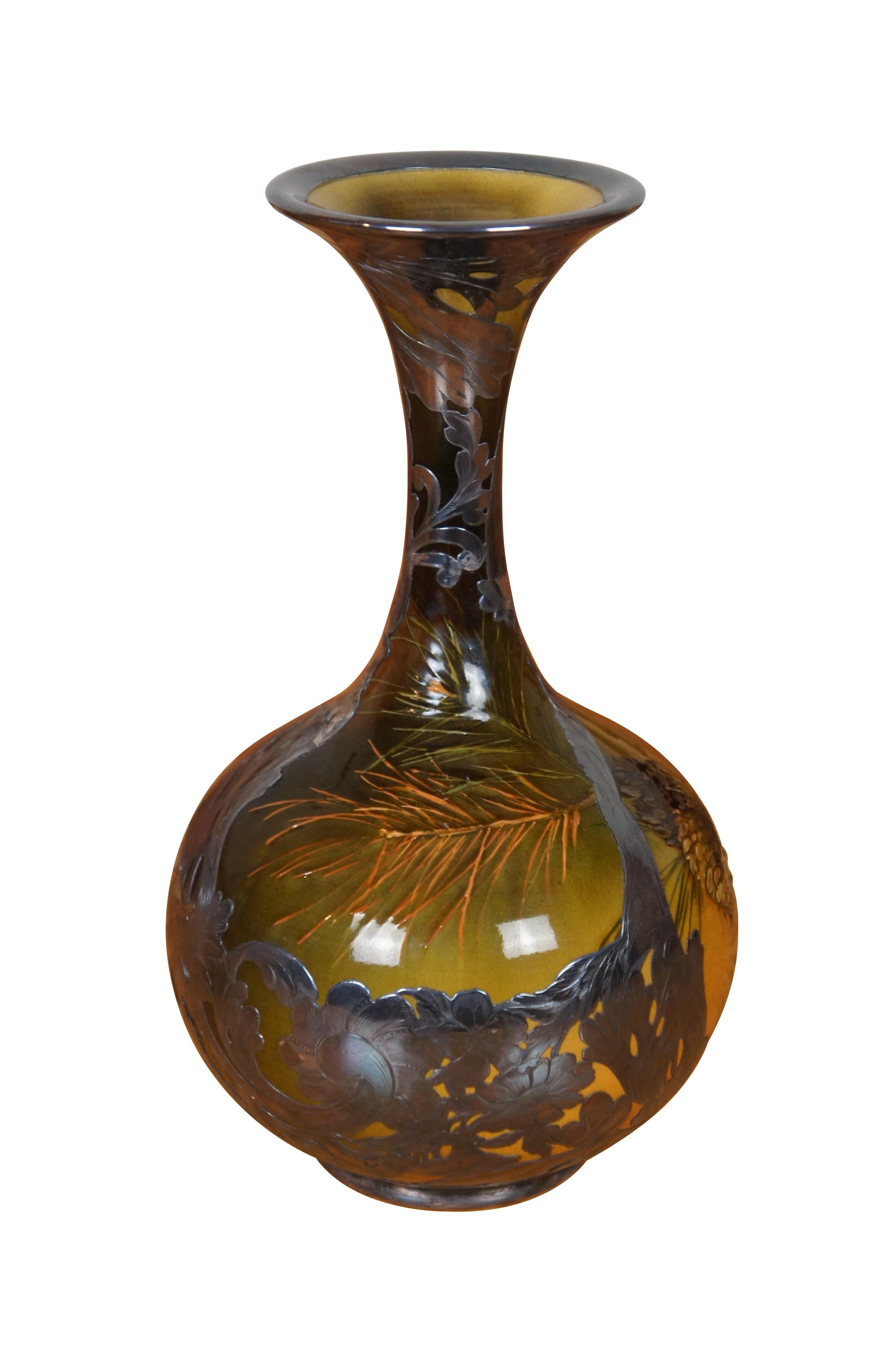Raro, molto grande e imponente vaso da camino antico Rookwood e Gorham di Amelia Sprague.  Presenta il tema della pigna e dell'albero di pino in stile Art Nouveau con argento sterling sovrapposto allo smalto iris.  Circa 1893.  Forma 387, Taglia B,