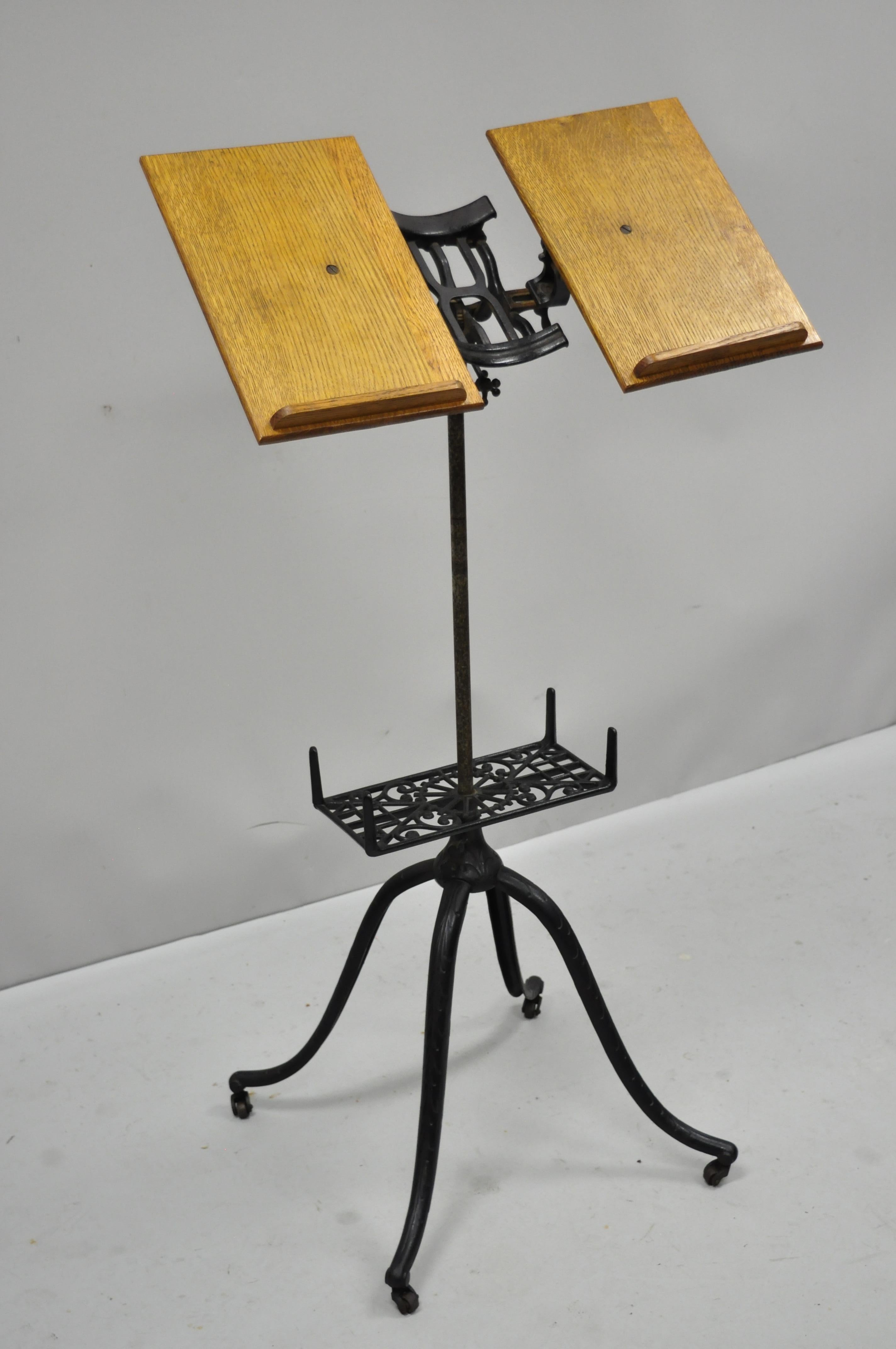 Antique 1895 adjustable cast iron and oak book music stand. Item features cast iron adjustable base, cast iron mechanics, solid oakwood 