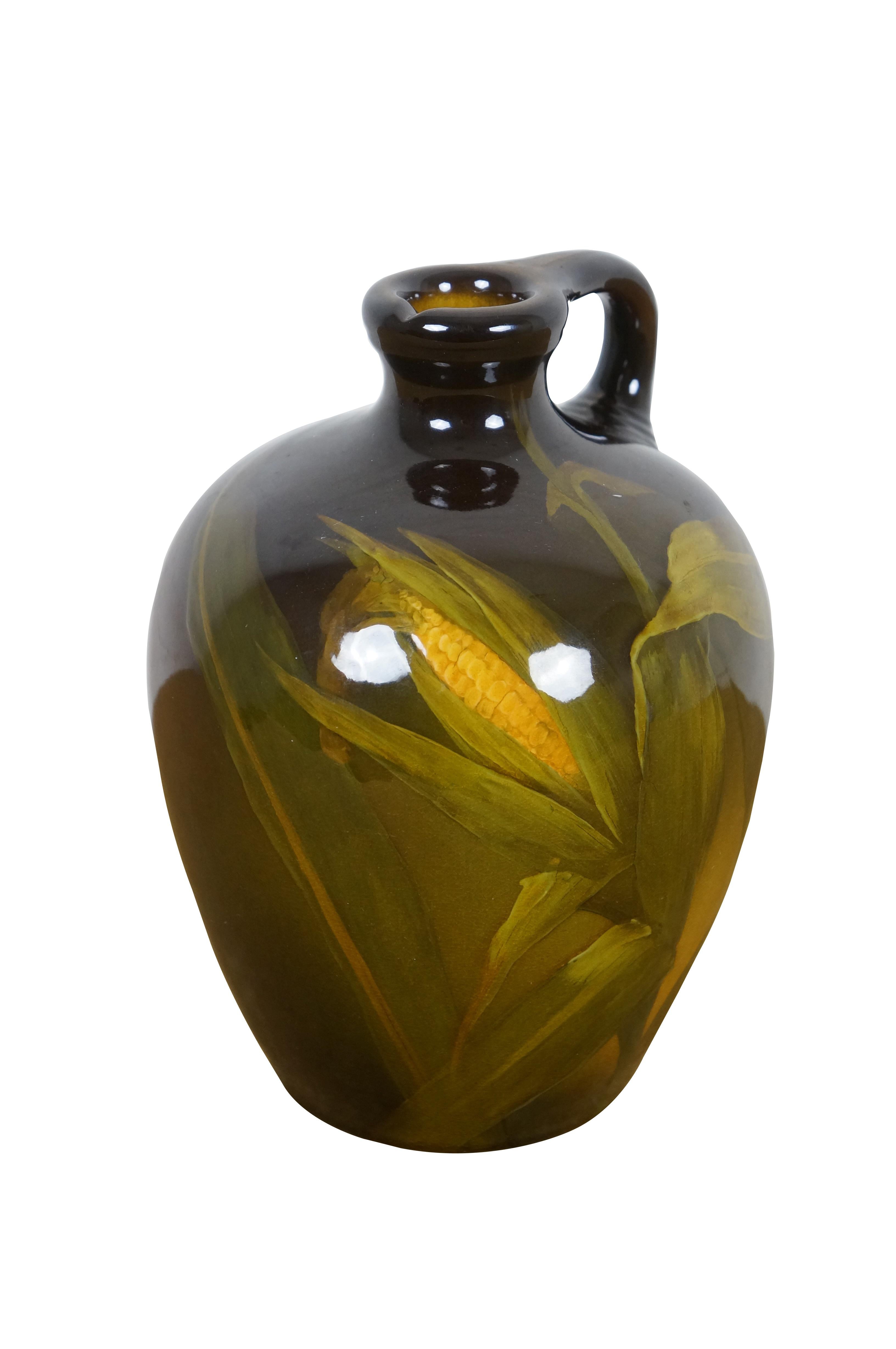 Antike 1897 Rookwood Pottery 512B Keramik glasiert Krug / Krug / Vase von Künstler Harriet E. Wilcox. Ein mittelgroßer Whiskeykrug mit Henkel, verziert mit einem eindrucksvollen, leuchtenden Maisstängel in goldgrünem bis dunkelbraunem