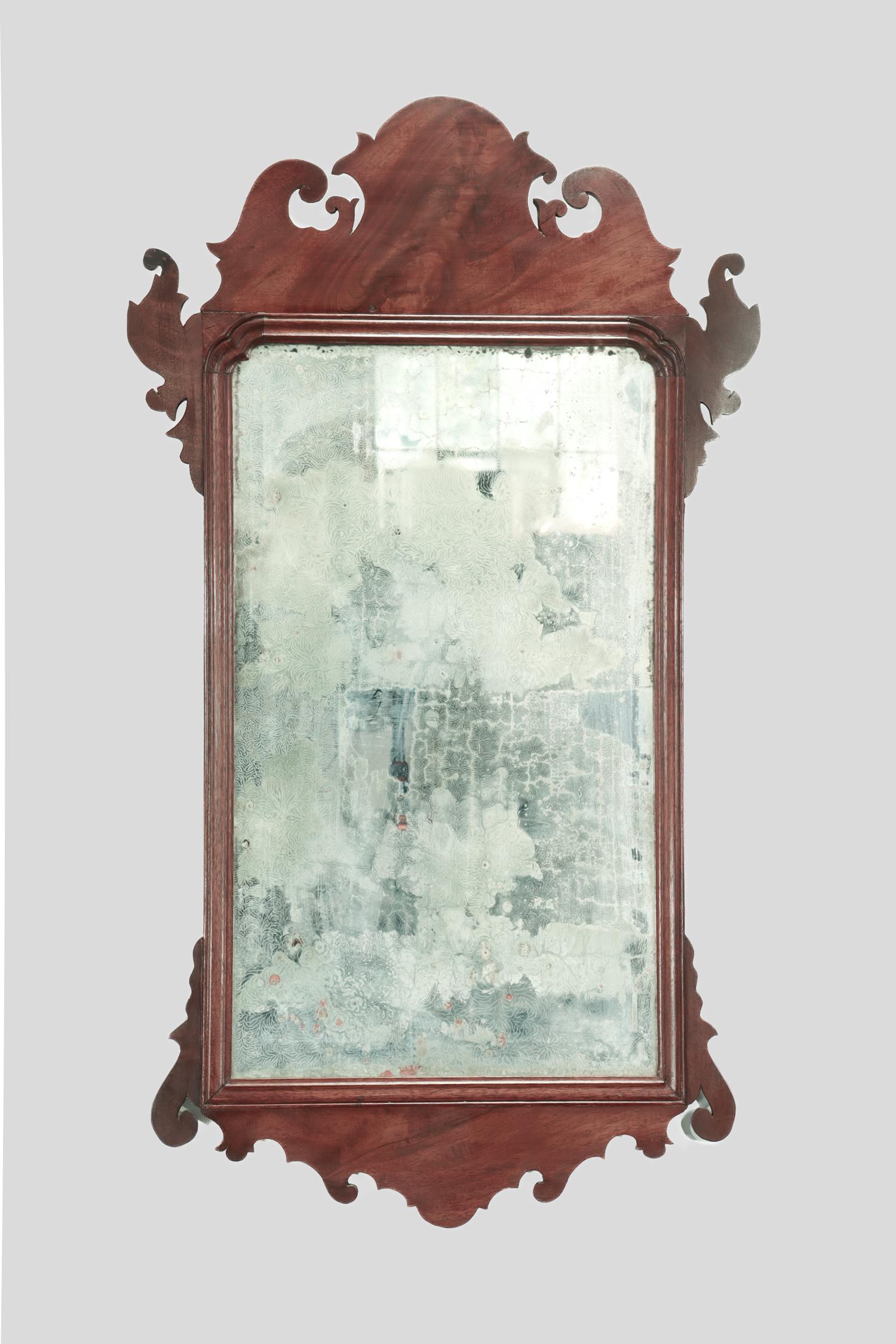 A fine antique Chippendale mirror.

With a mahogany veener.

Attributed to John Elliot of Philadelphia.

Having Elliot's typical scrolled crest and molded inner band with central mirror plate flanked by scrolled ears above a shaped apron.

Retains