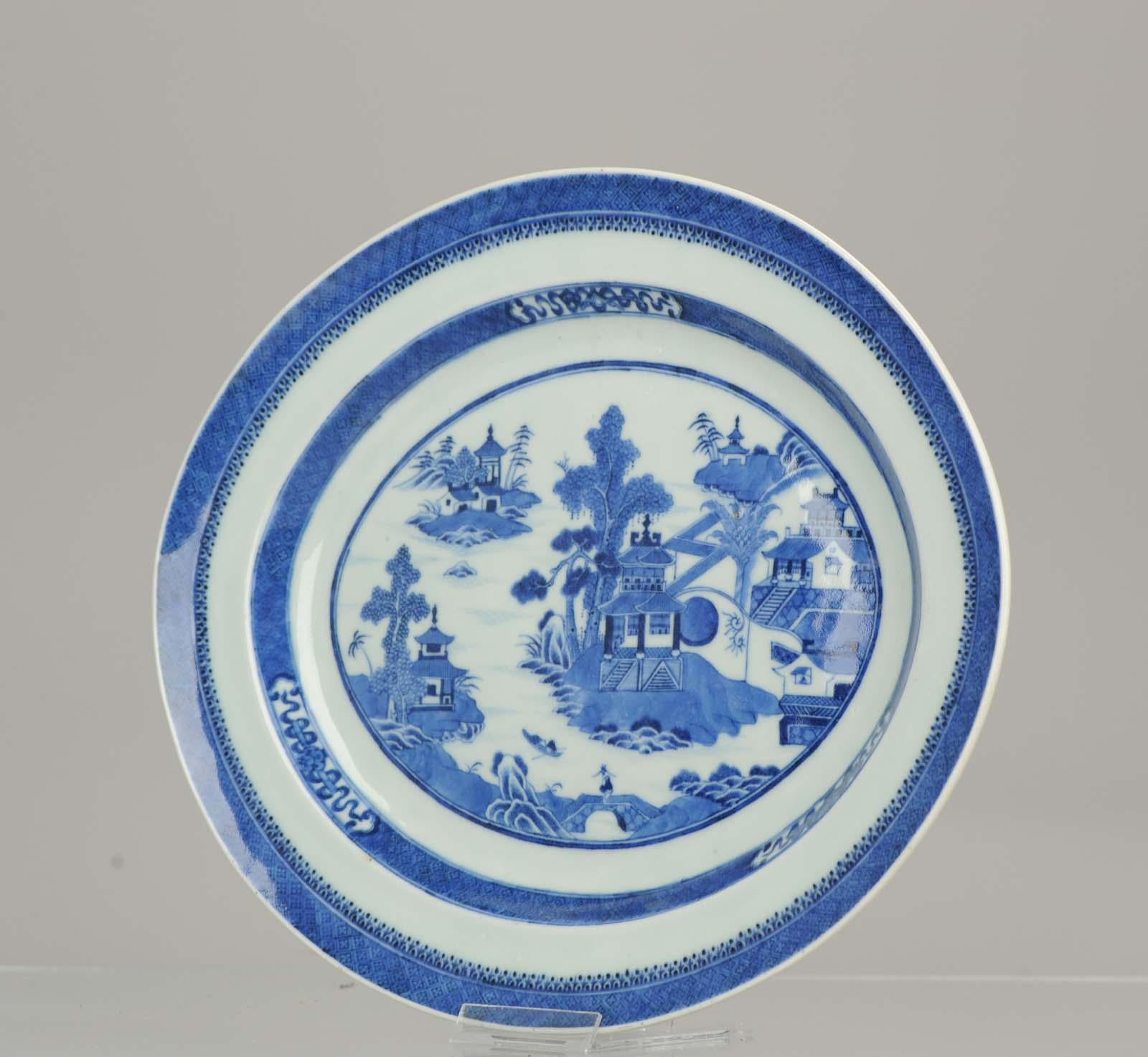An excellent, shallow and large serving dish, exceptionally finely painted in underglaze blue with central reserve of an island village with pagodes, palm trees and fishermen. Further tasteful concentric borders of dark diaper pattern, 18th