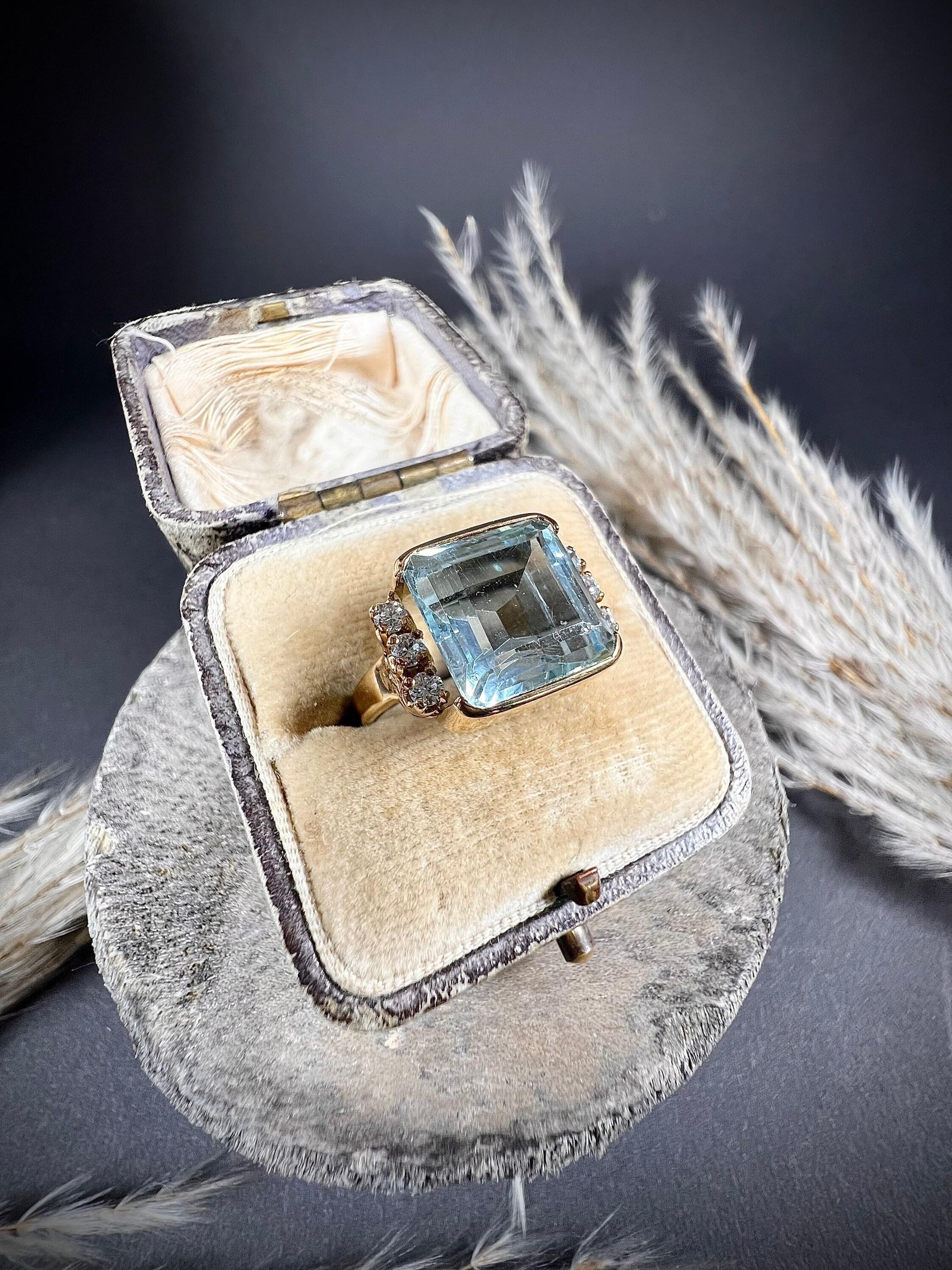 Antique Aquamarine Ring 

18ct Yellow Gold Tested

Circa 1920’s

Fabulous, antique cocktail ring. Set with a gorgeous, square, natural aquamarine. Framed in a rub over, yellow gold setting. Complimented beautifully by a trio of natural- claw set-