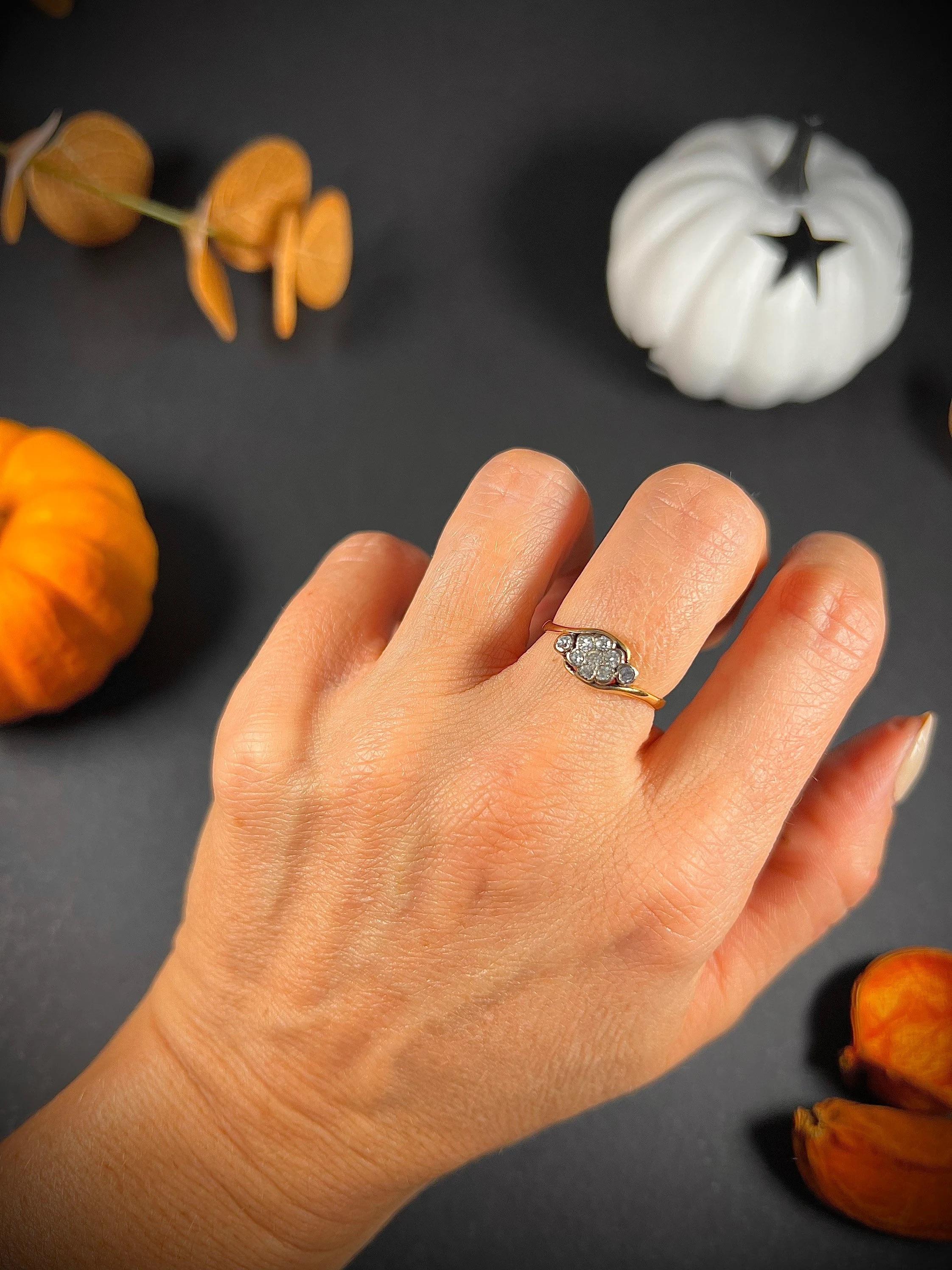 Antique Daisy Ring 

18ct Gold 

Circa 1900

Beautiful, Edwardian daisy ring. Mounted on a twisted band with two diamonds either side of the centre daisy. 

Face of the ring measures approx width 10.6mm & height 6.8mm 

UK Size L

US Size 6

Can be