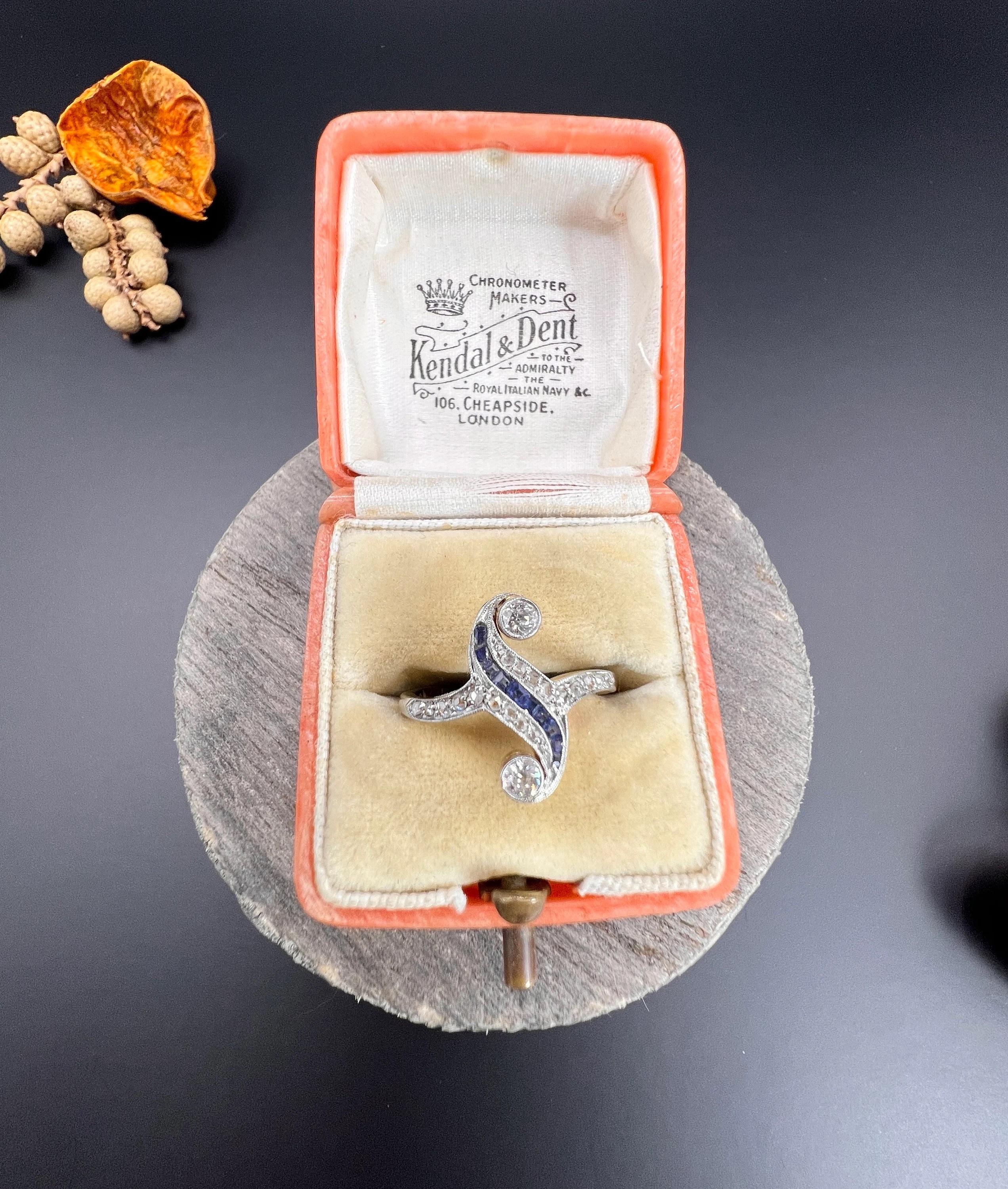 Antique Sapphire and Diamond Art Deco Ring 

18ct Gold & Platinum Stamped 

Circa 1920s

Introducing an exquisite original Art Deco ring crafted from 18ct gold. The ring features a fabulous swirl design with calibrated natural sapphires set