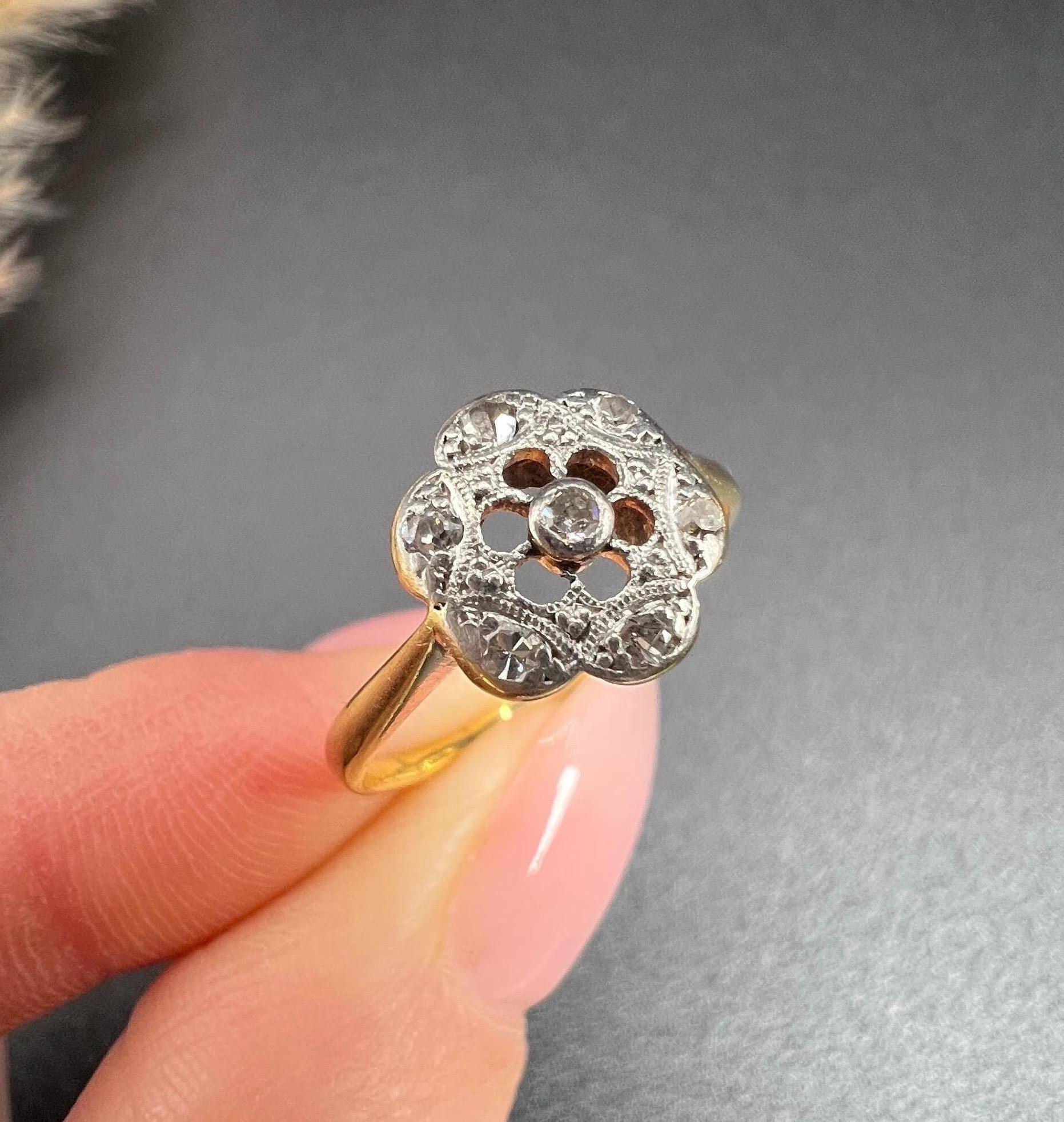 Antique Diamond Daisy Ring 

18ct Gold & Platinum

Circa 1920s

Step back in time with this exquisite 1920s antique Daisy Ring, a true embodiment of vintage elegance. Crafted from luxurious 18-carat yellow gold, this enchanting piece features a