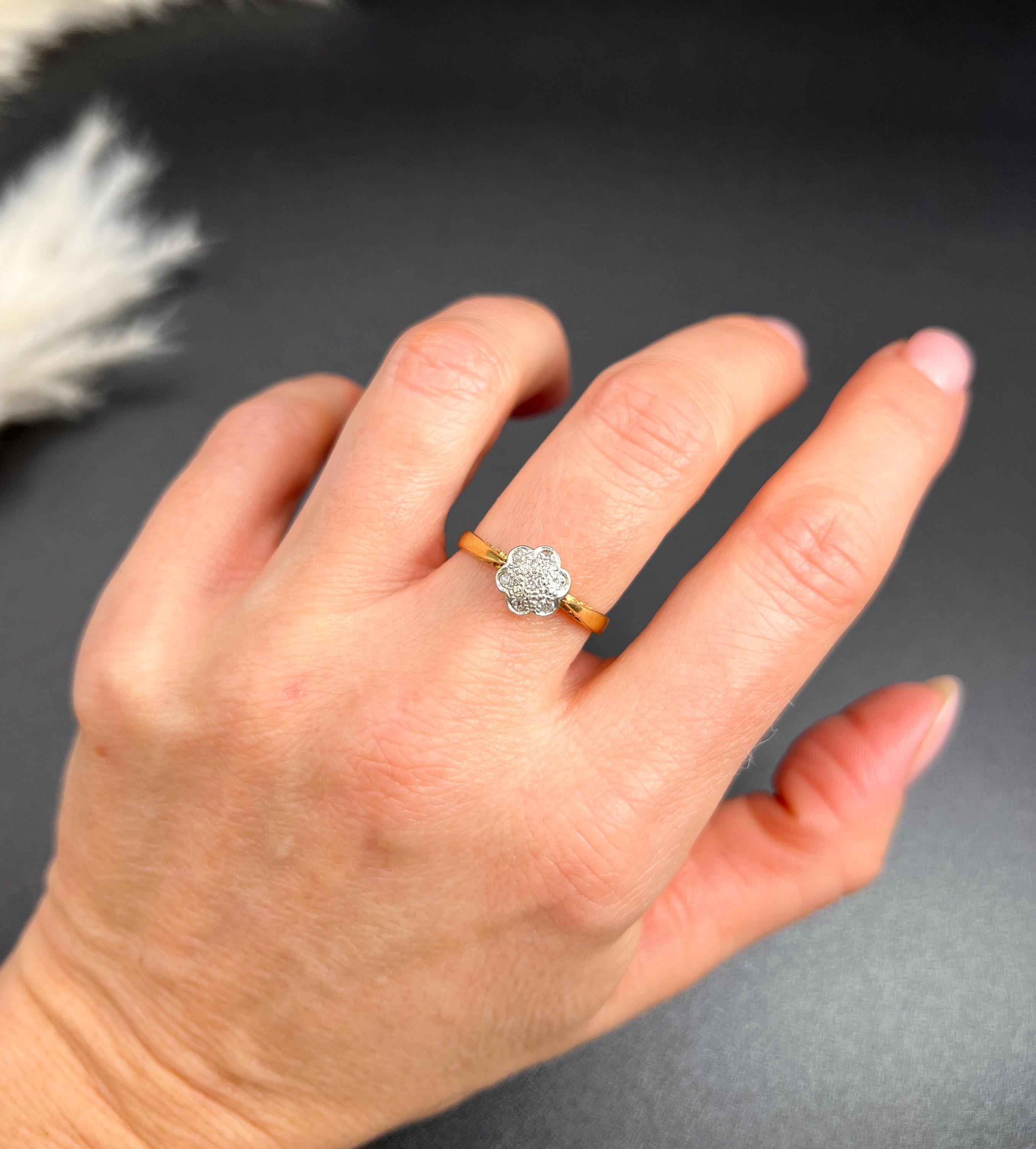 Antique Diamond Daisy Ring 

18ct Gold & Platinum Stamped 

Circa 1920s

Step back in time with this exquisite 1920s Antique Daisy Ring, a true embodiment of vintage elegance. Crafted from luxurious 18ct yellow gold, this enchanting piece features a