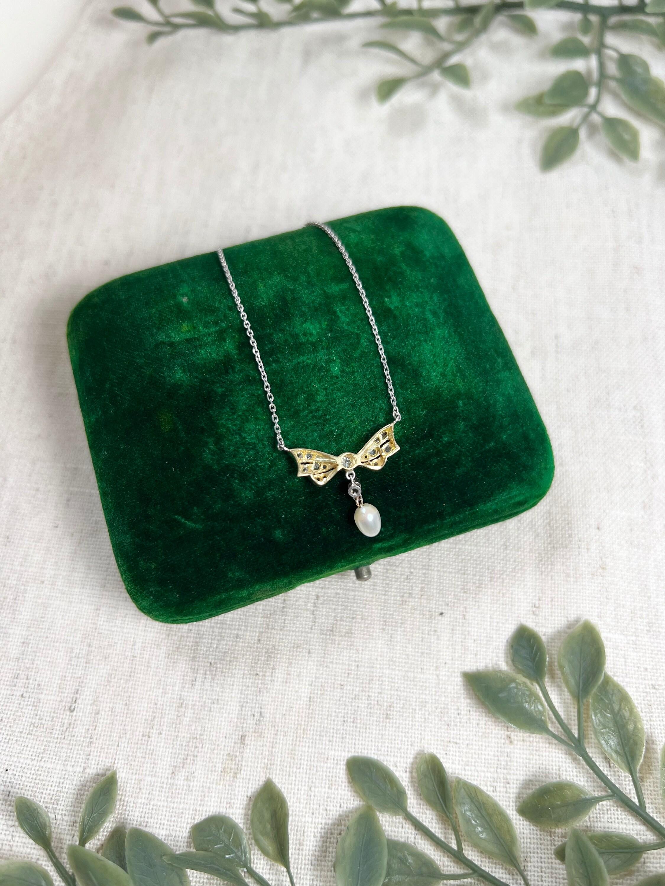 Antique Bow Necklace 

Platinum & 18ct Gold 

Circa 1910

Pretty, Edwardian necklace. Features a lovely little bow shaped pendant, set with natural, old European cut diamonds & a natural pearl drop. 
The stones are set in platinum & the back of the