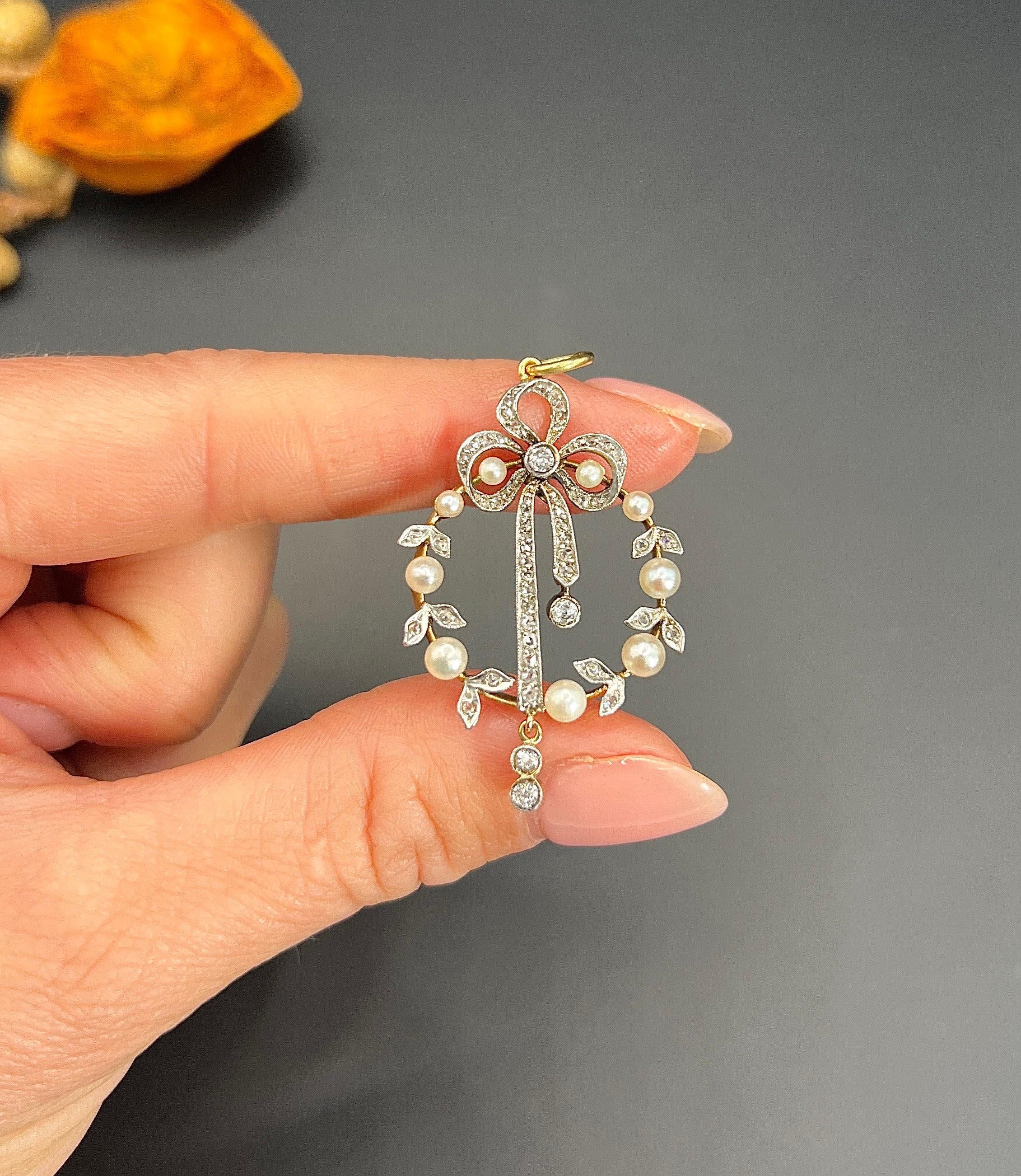 Antique Bow Pendant 

18ct Gold & Platinum Tested

Circa 1910

*THE CHAIN IS SOLD SEPARATELY. 

Introducing an exquisite piece from the Edwardian era, this 18ct gold and platinum pendant is a true marvel. Adorned with a delicate laurel wreath