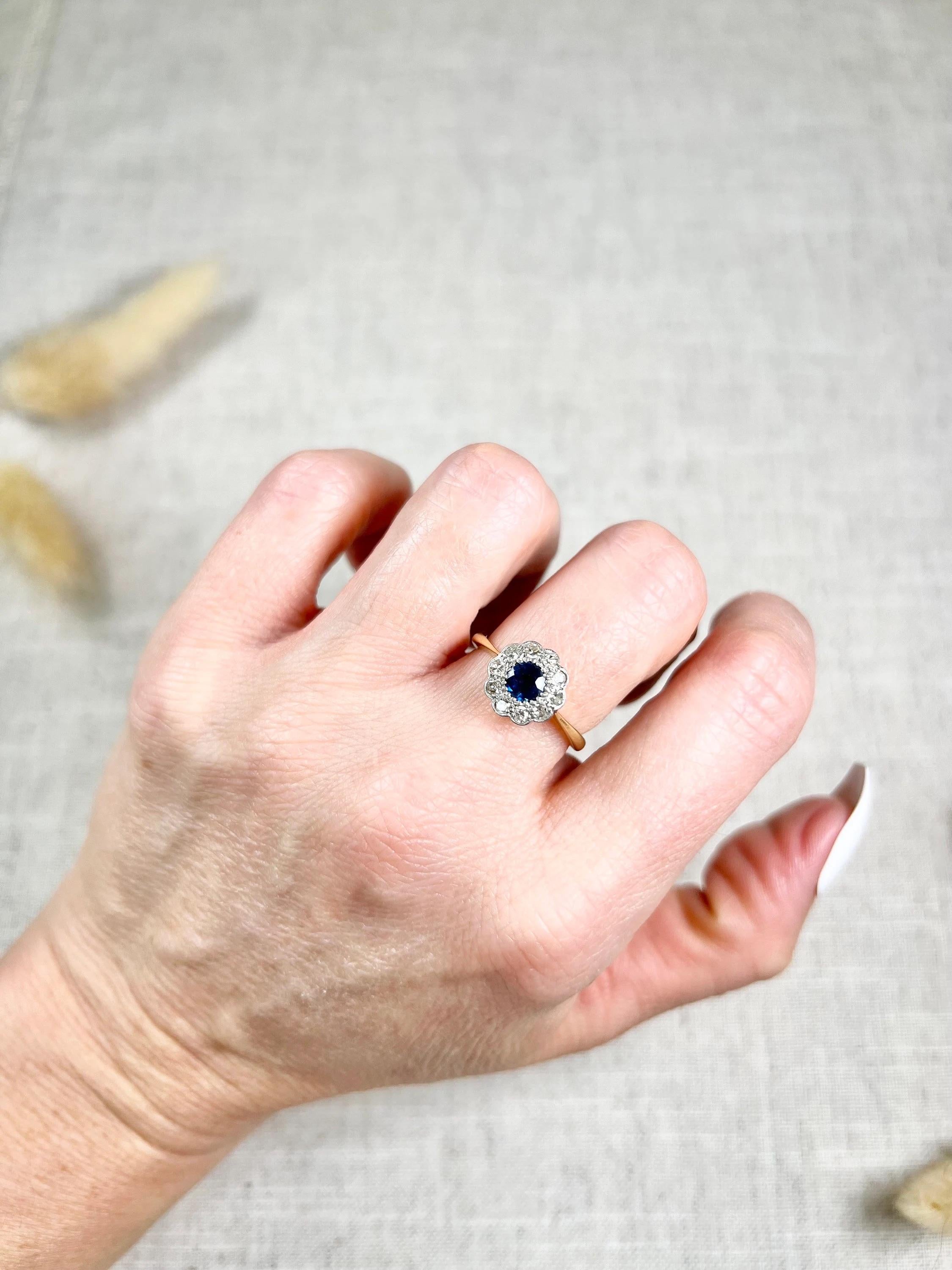 Antique Daisy Ring

18ct Gold & Platinum Stamped 

Circa 1910

This stunning Edwardian ring is a daisy-style cluster ring that exudes elegance and sophistication. Crafted in 18ct yellow gold, this ring features a beautiful centre natural sapphire